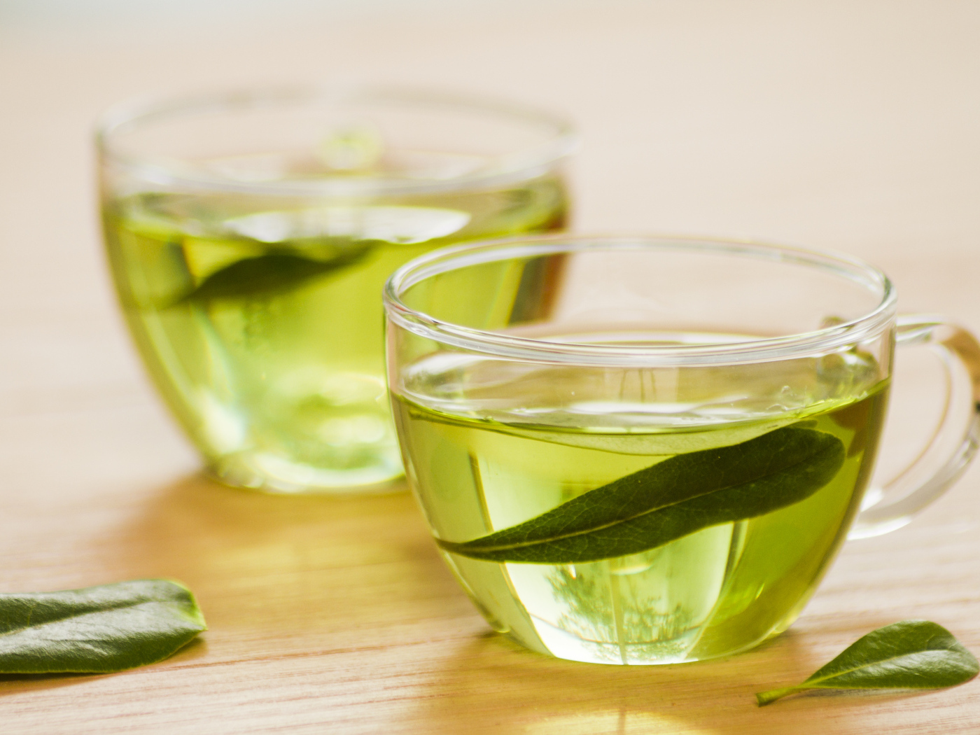 Две чашки зеленого чая с листьями