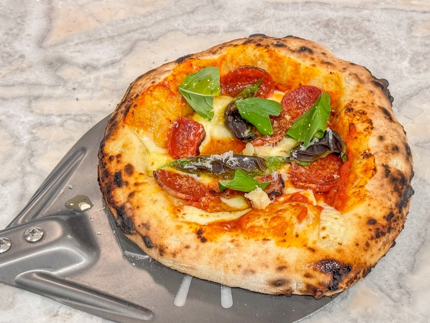 Маленькая пицца на лопате на столе