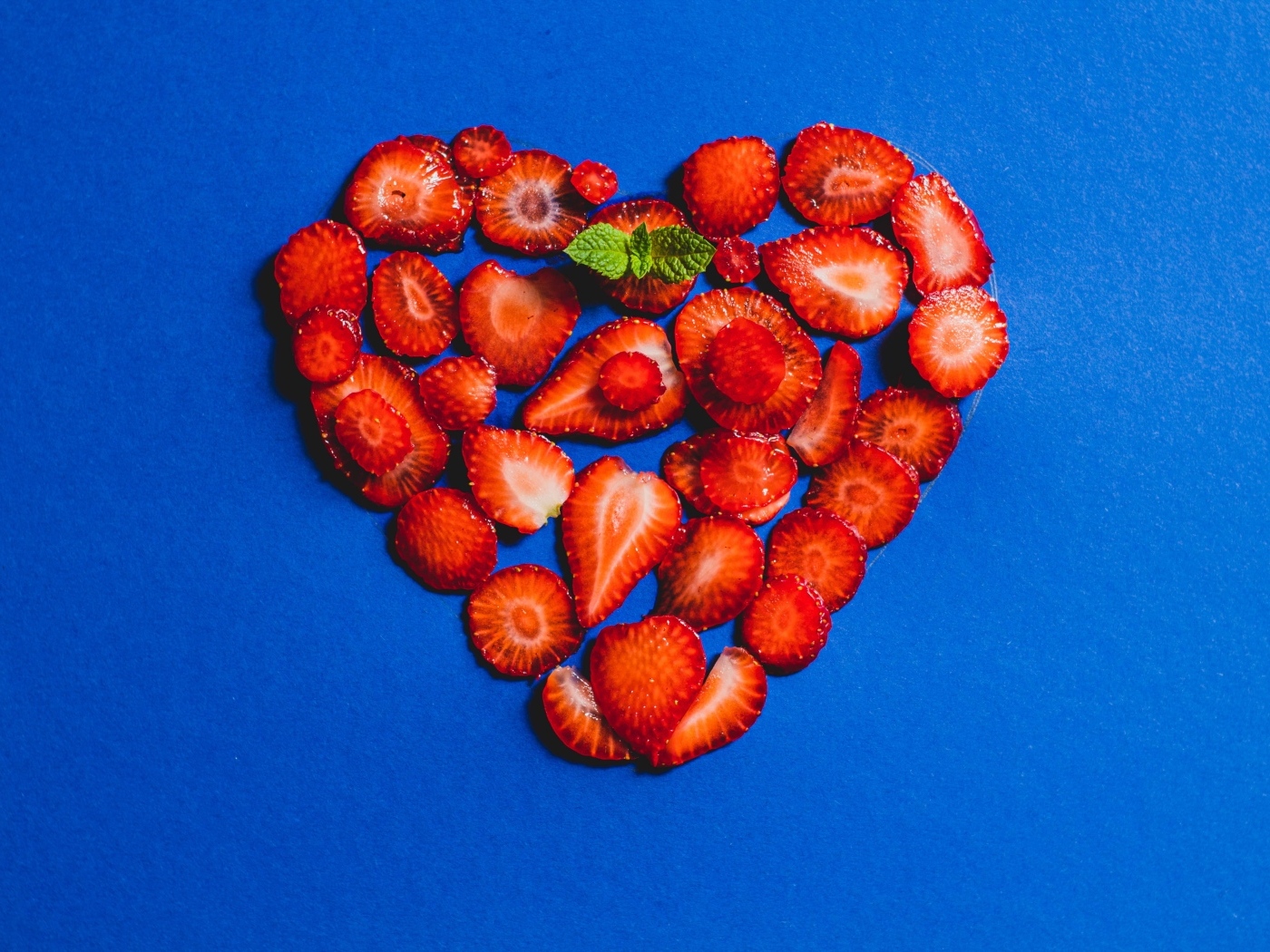 Сердце из сушеной клубники на синем фоне