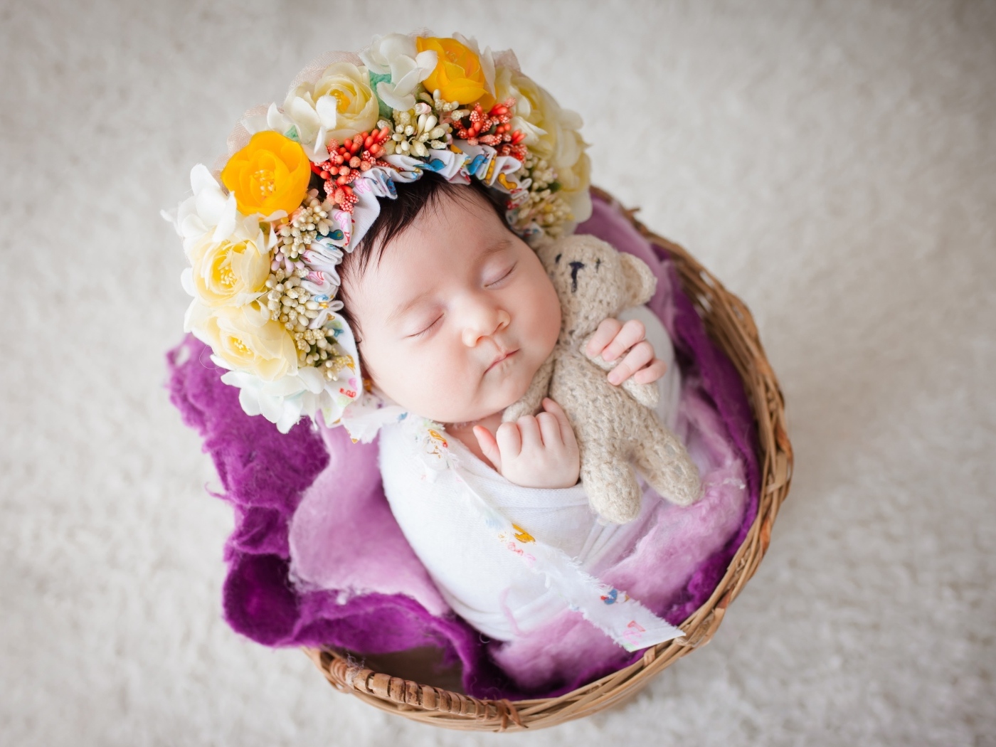 Младенец с венком на голове спит в корзине