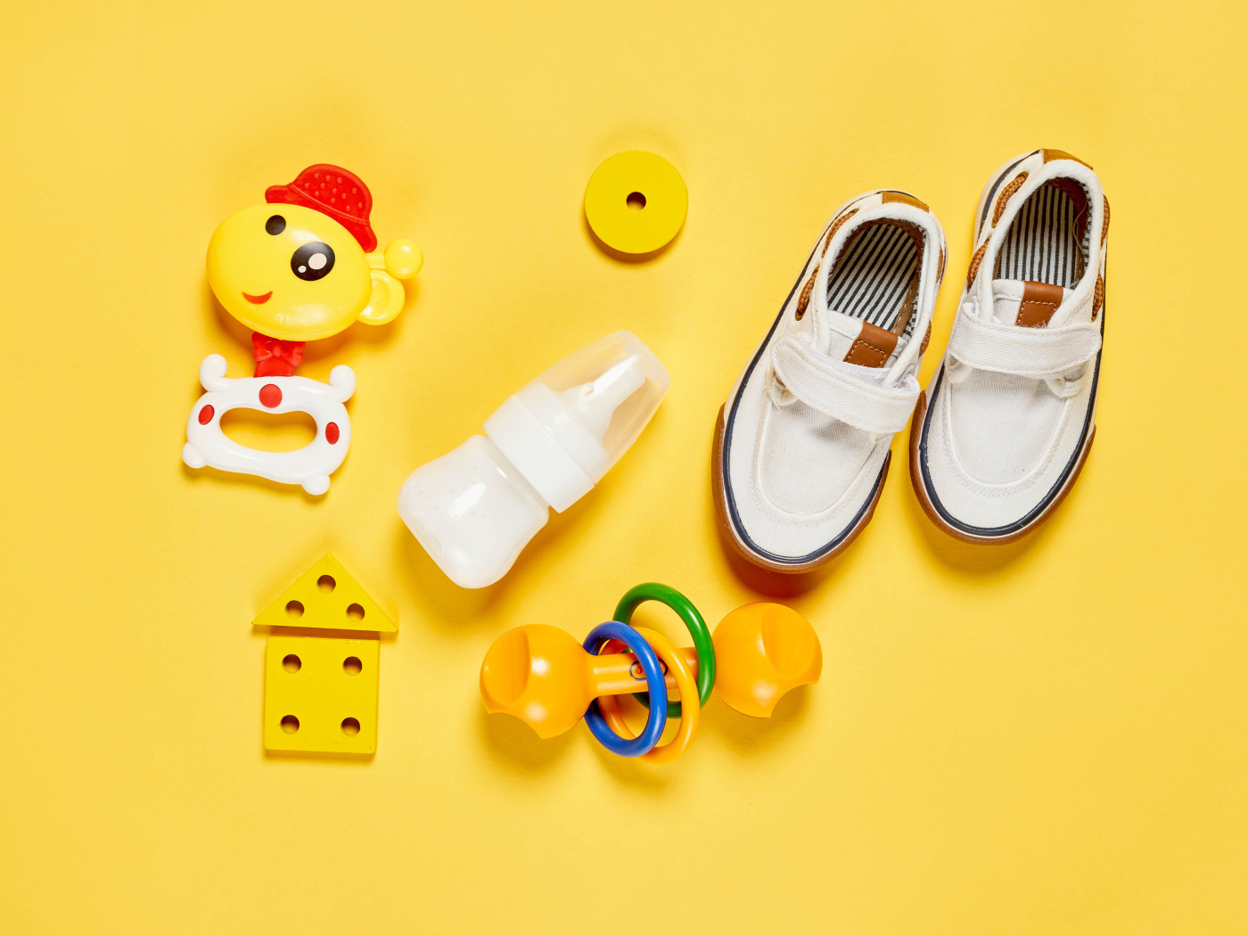 Детские игрушки и обувь на желтом фоне