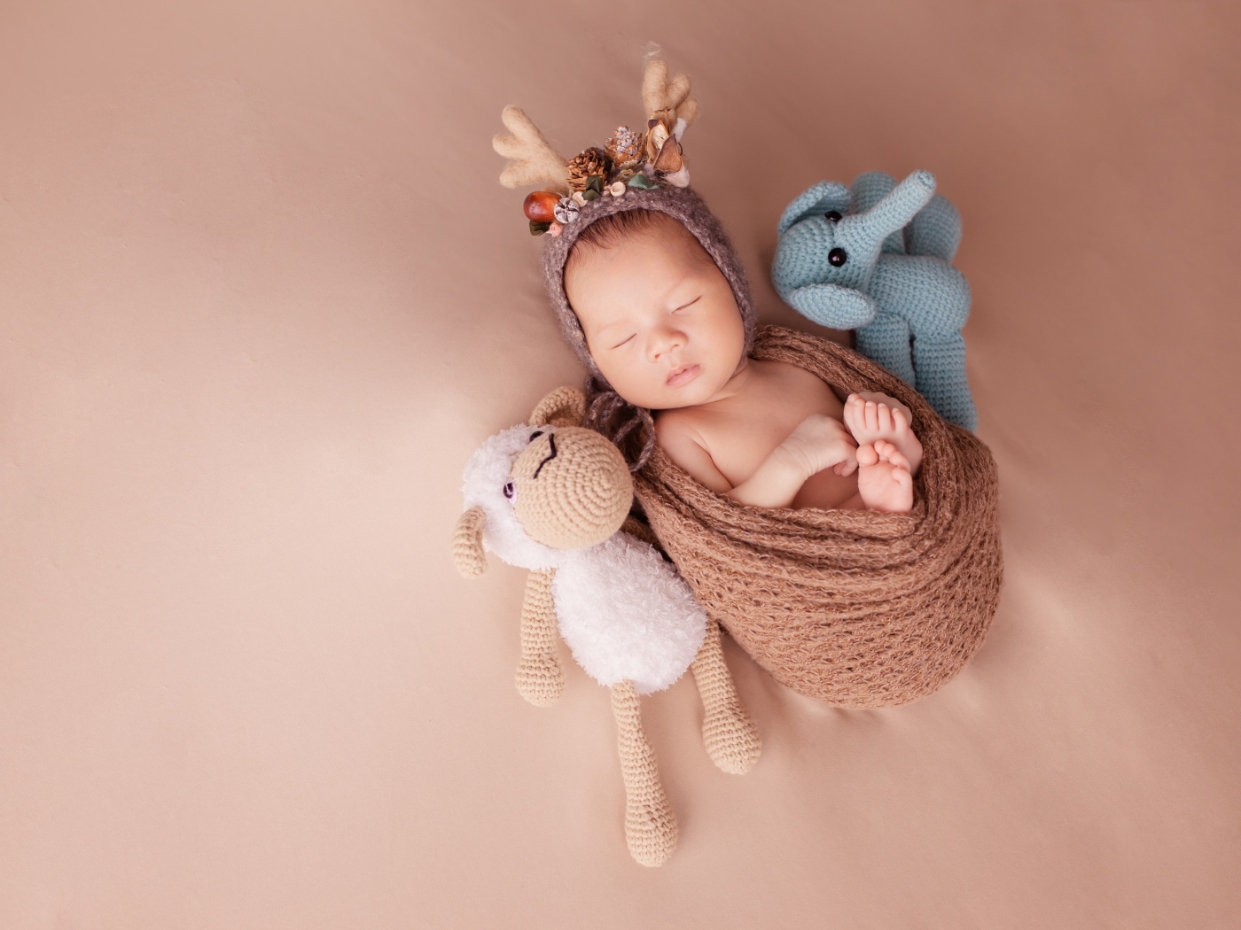 Маленький ребенок в костюме оленя с игрушкой