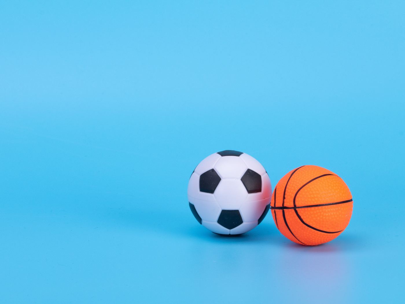 Футбольный и баскетбольный мяч на голубом фоне