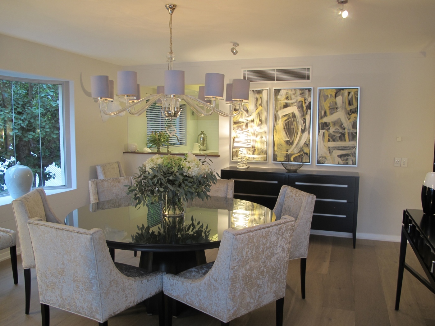 Большой стол со стульями в столовой с большой люстрой