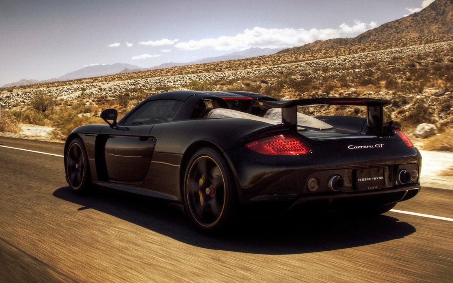 Черный автомобиль мчится по дороге