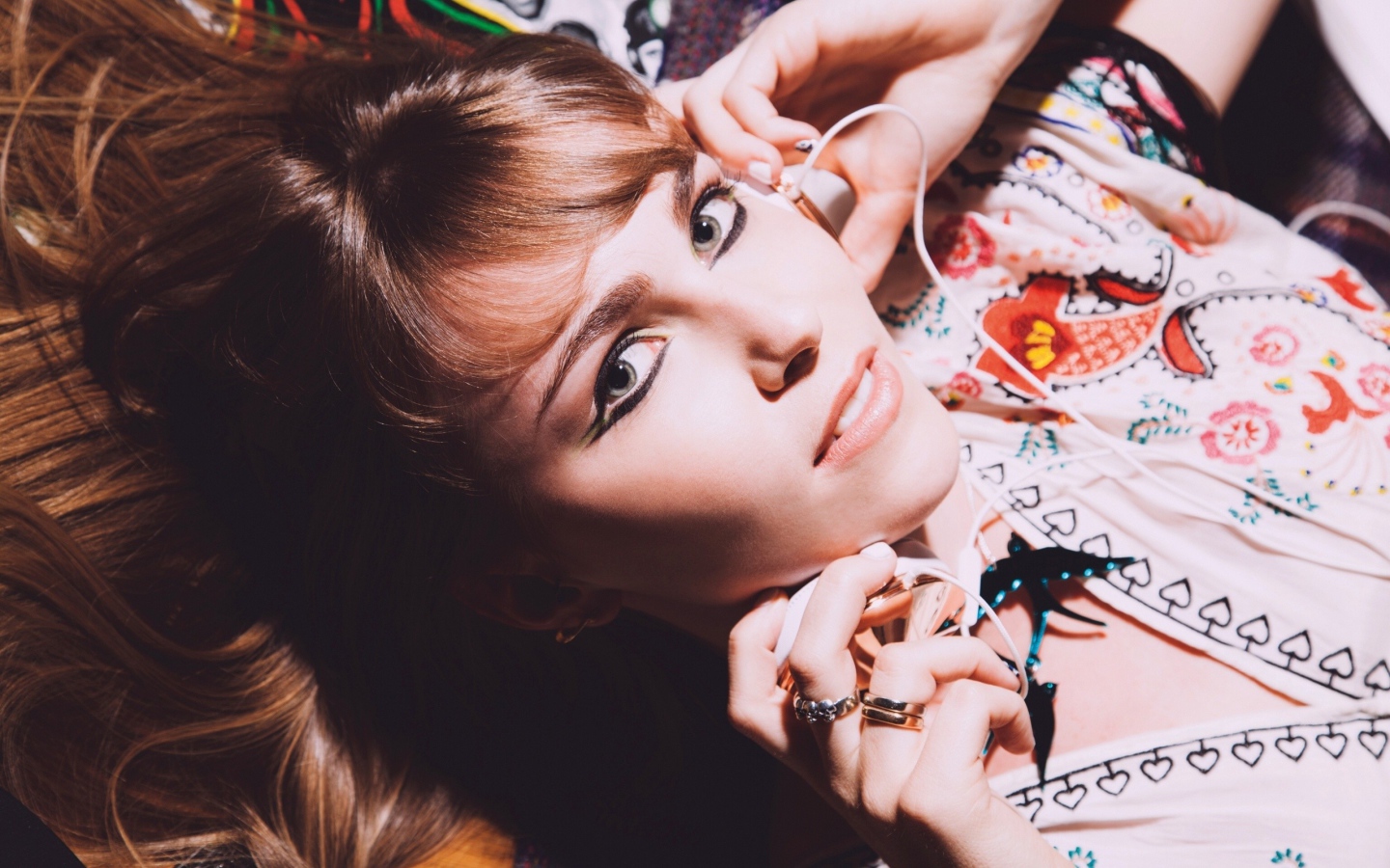 Девушка лежит с наушниками