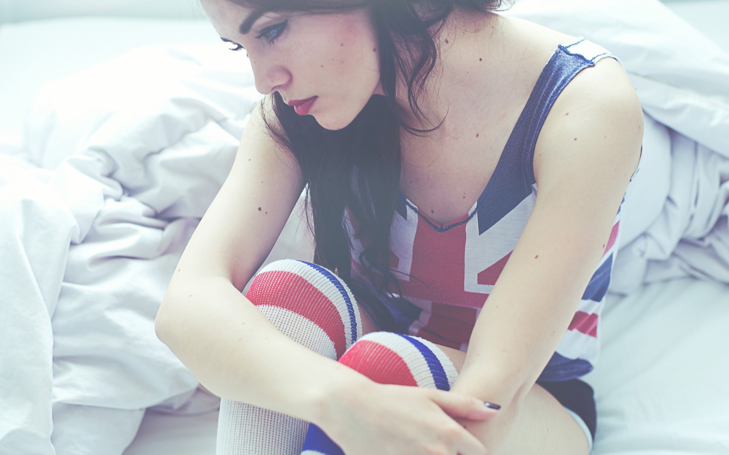 Девушка грустит на кровати