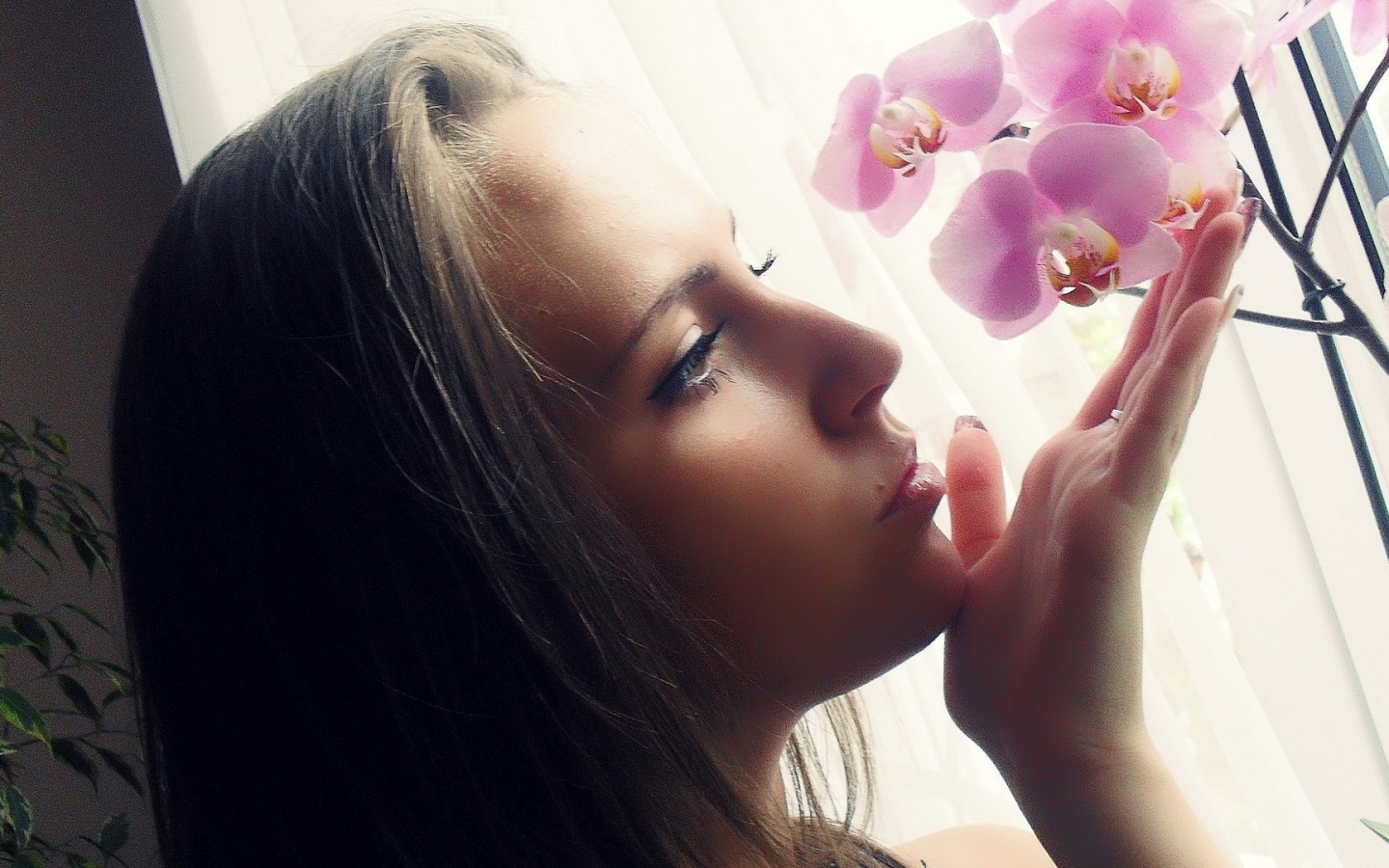 Девушка смотрит орхидею