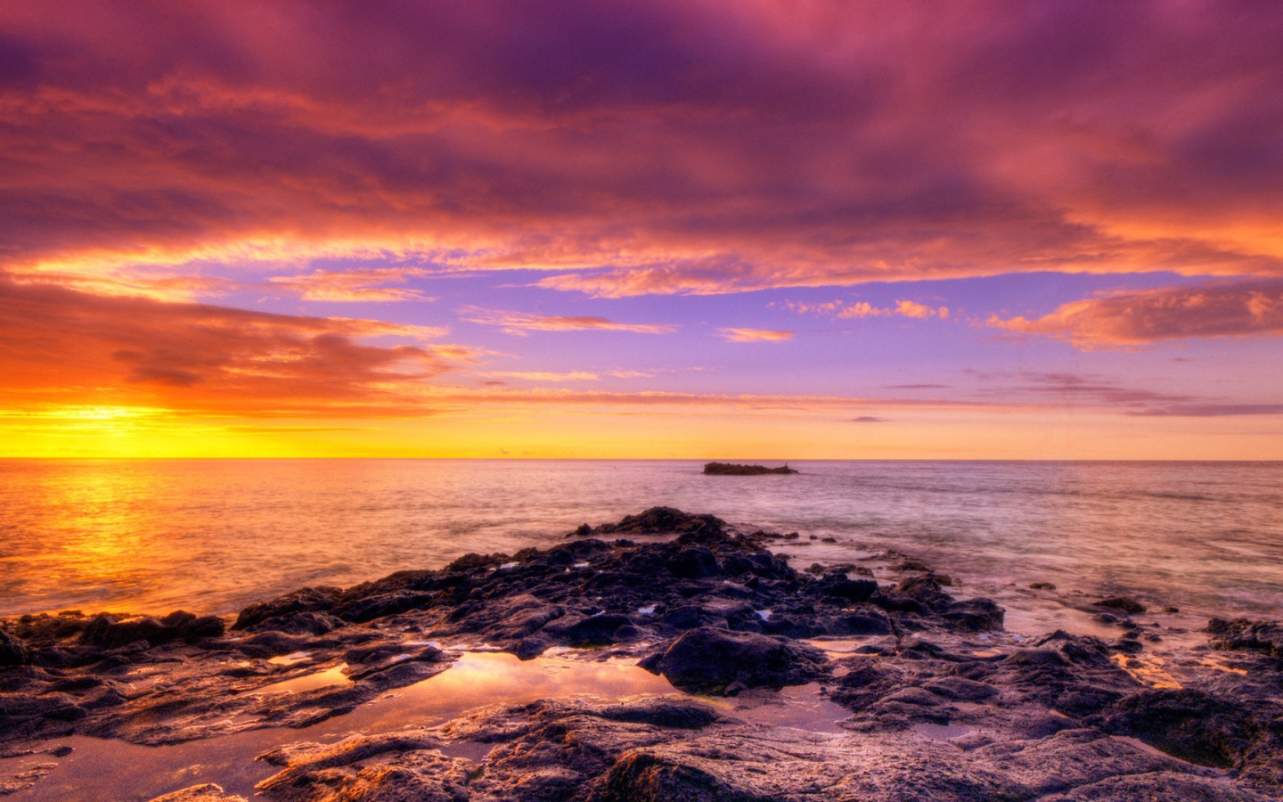 Разноцветный закат на каменистом побережье