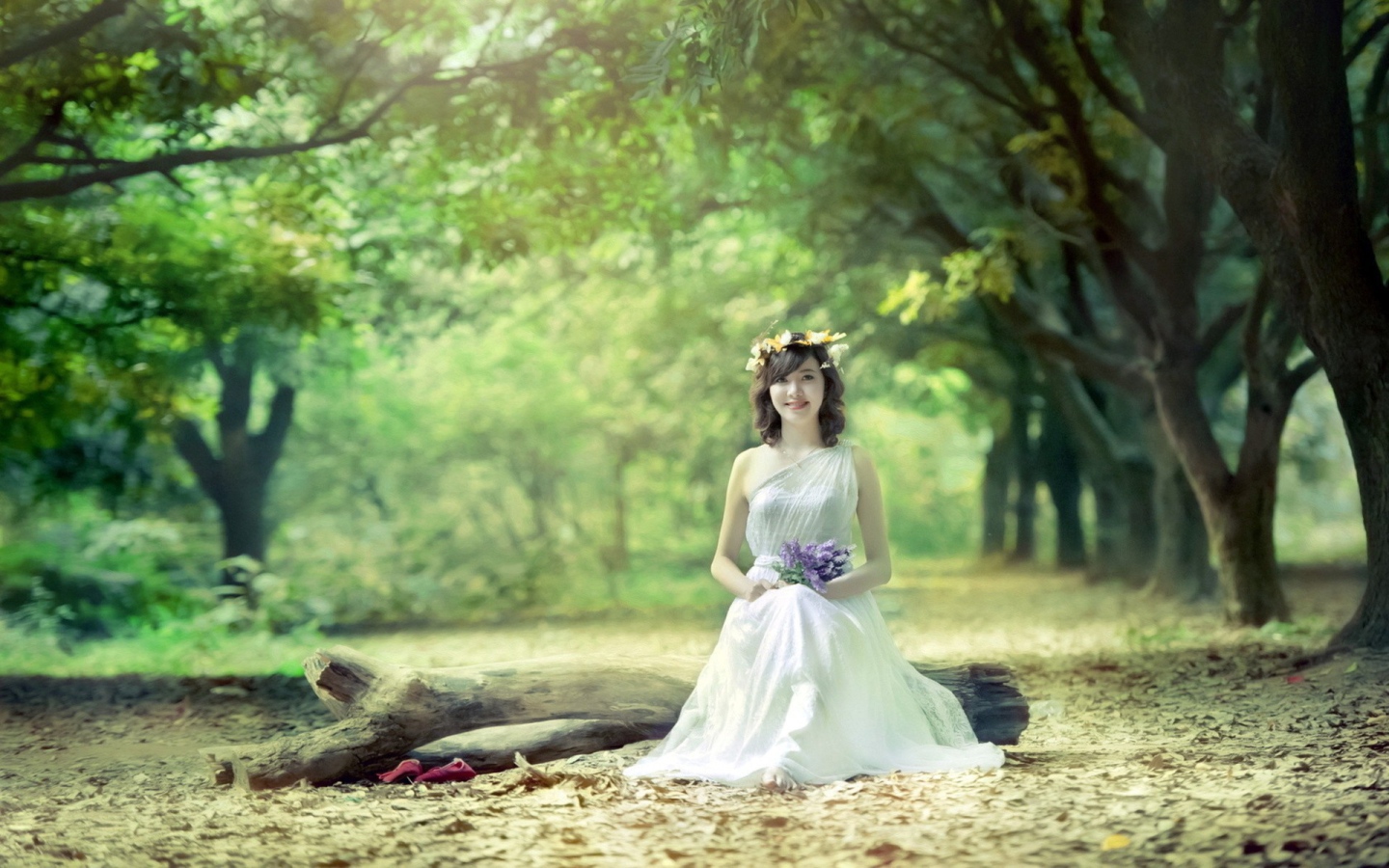 Девушка сидит на бревне