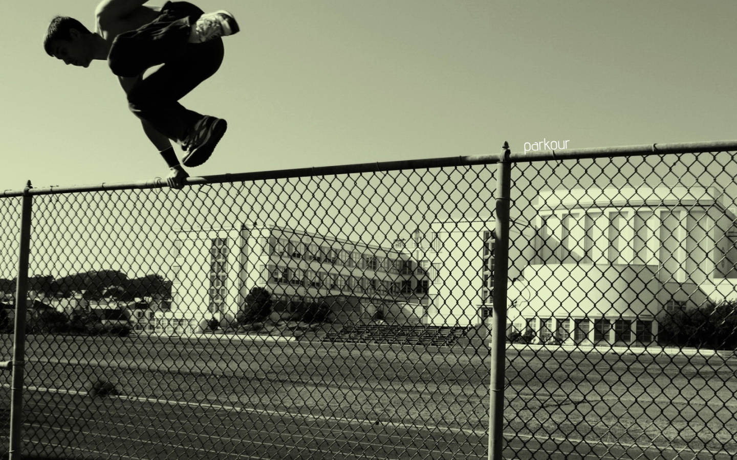Паркурщик прыгает через забор