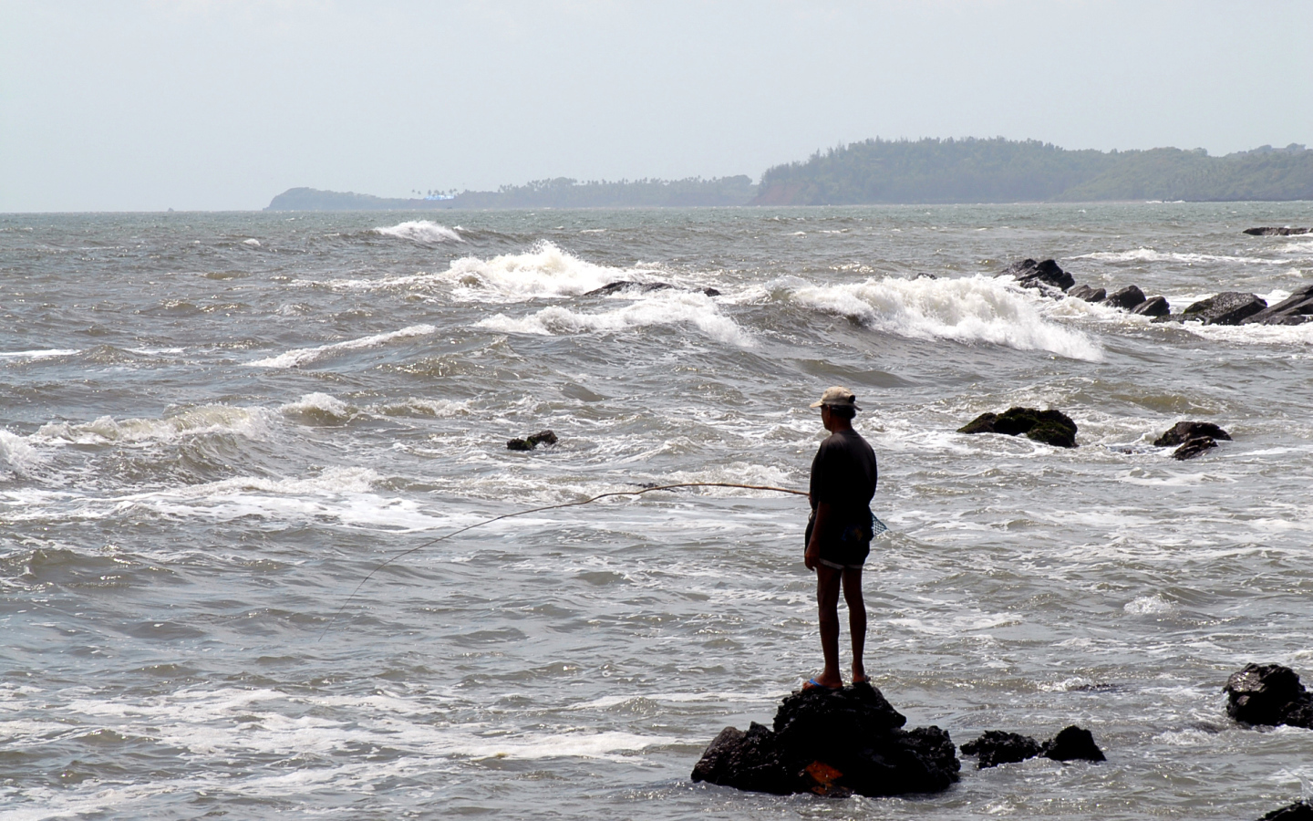Мужчина ловит рыбу в Гоа