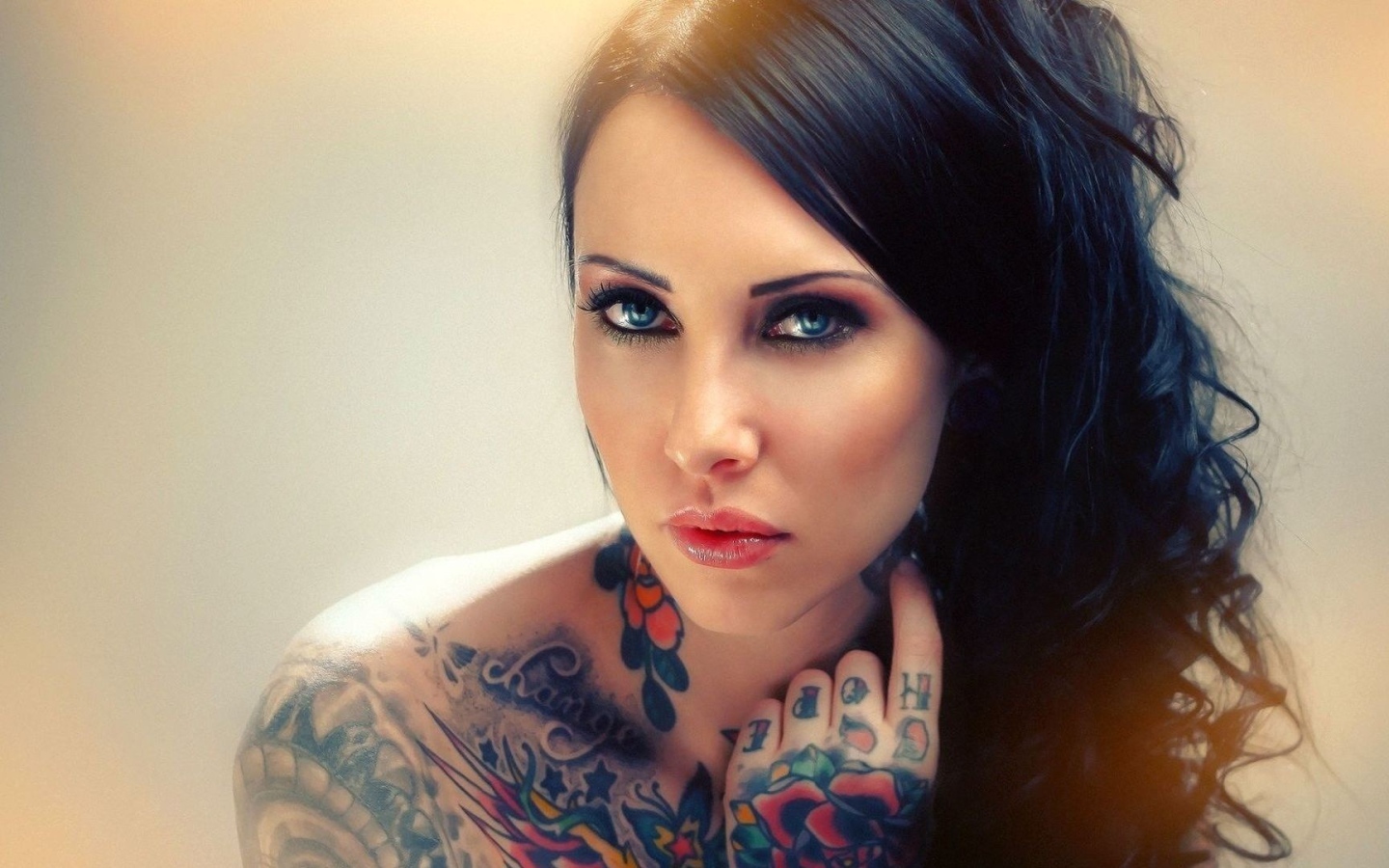 Голубоглазая девушка с татуировкой на руке и плече
