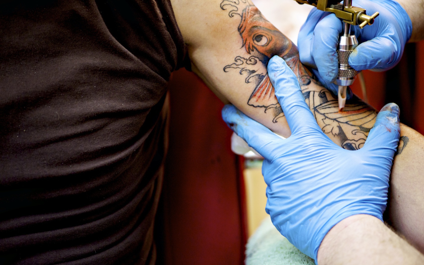 Девушке делают татуировку