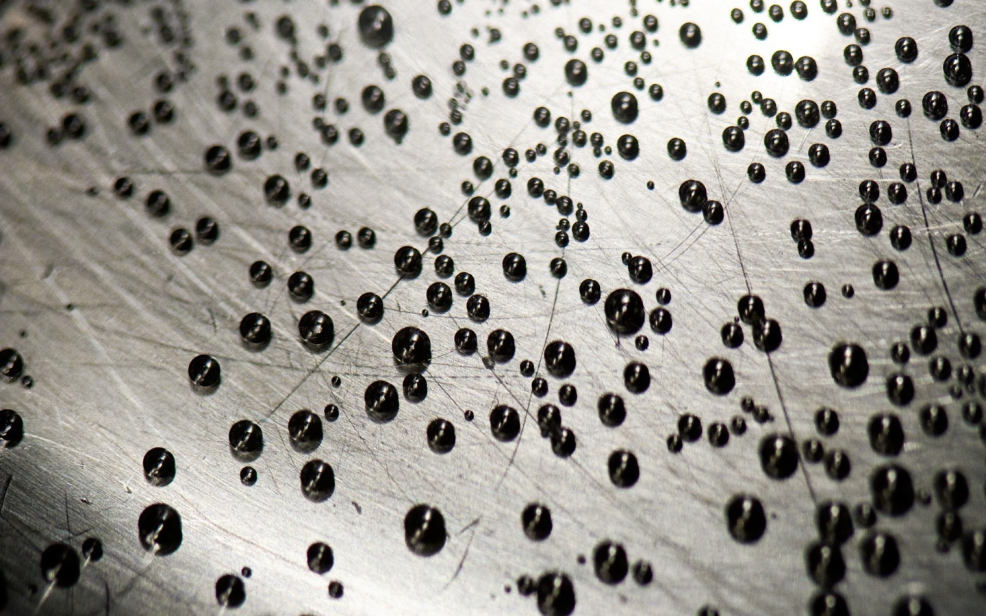 Мелкие черные шарики на серой поверхности