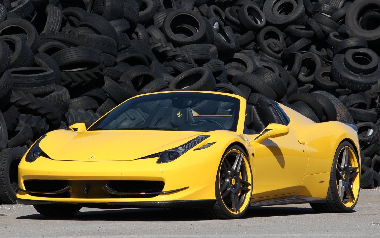 Желтый суперкар Ferrari 458 на фоне покрышек