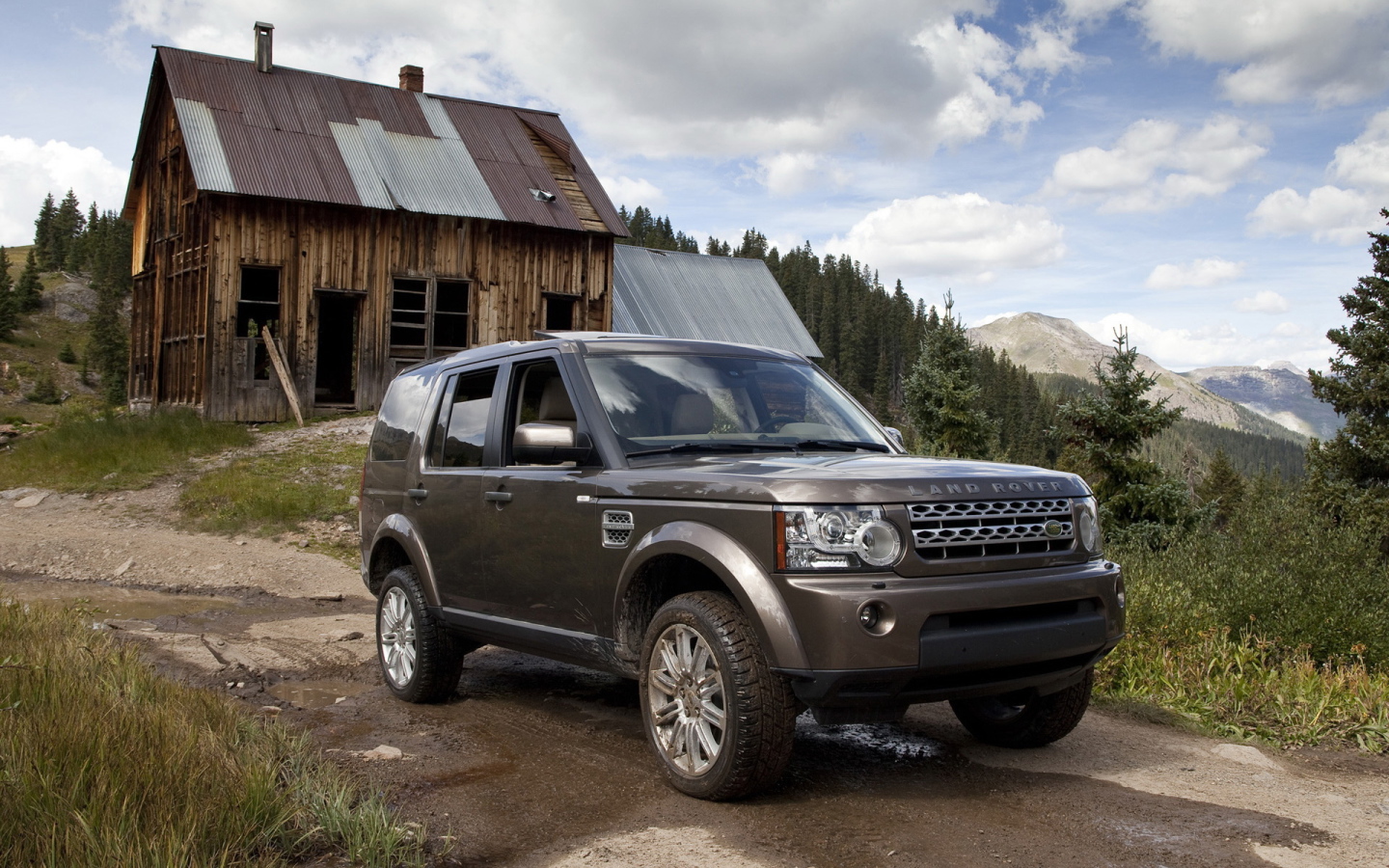 Темный Land Rover на фоне старого здания