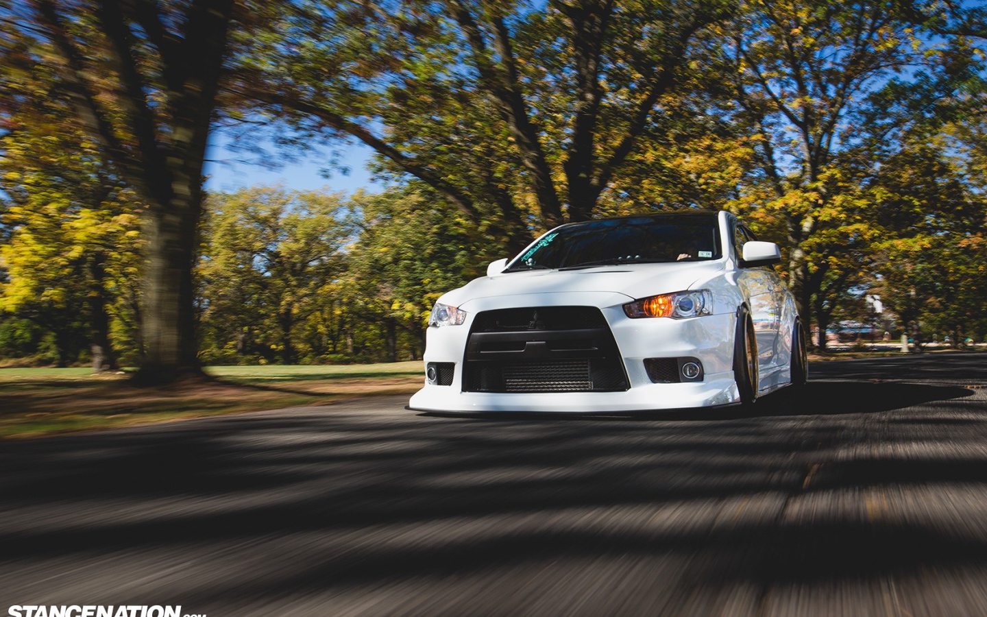 Белый Mitsubishi Lancer Evo X на дороге