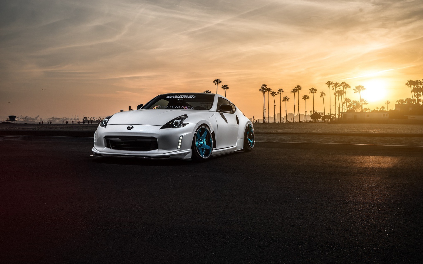 Белый Nissan 370Z на фоне пальм и заката