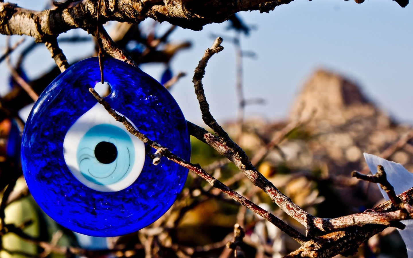 Оберег из синего стекла на дереве