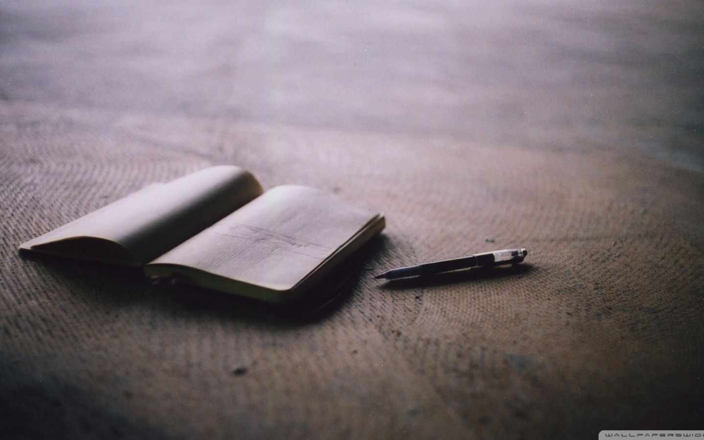 Записная книжка и ручка на полу