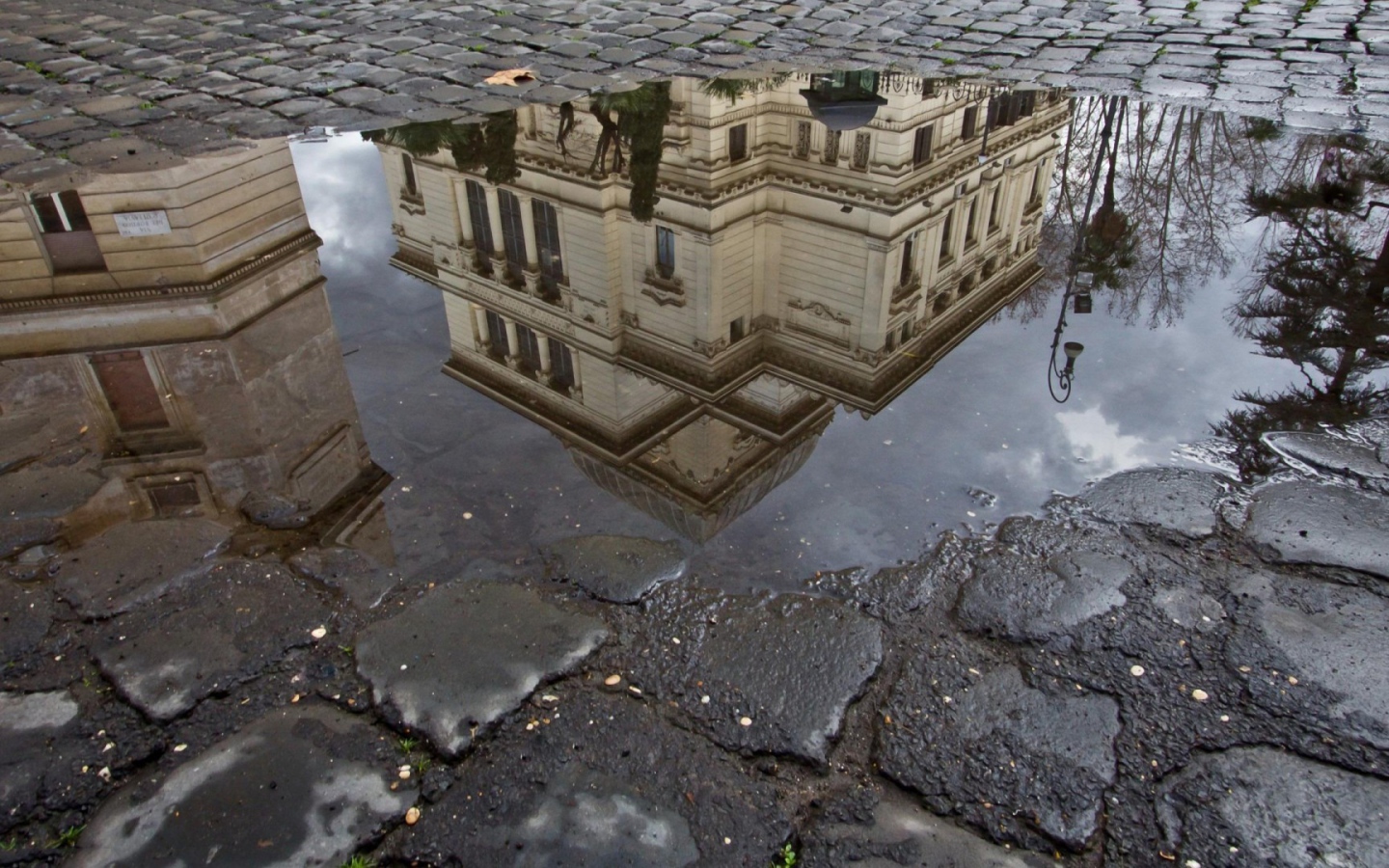 Отражение городского здания в луже