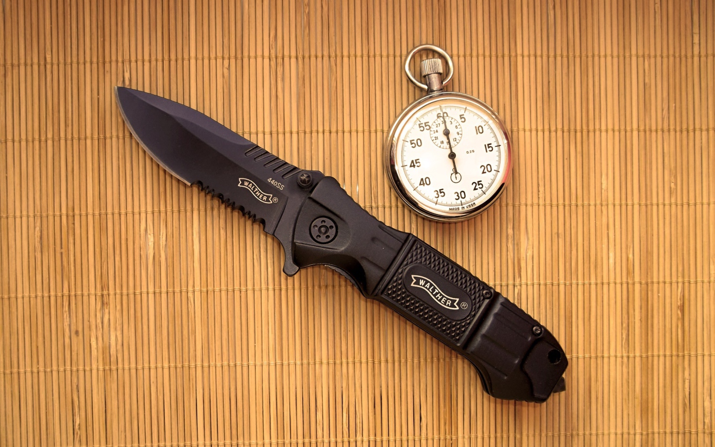 Часы и нож на бамбуковом коврике