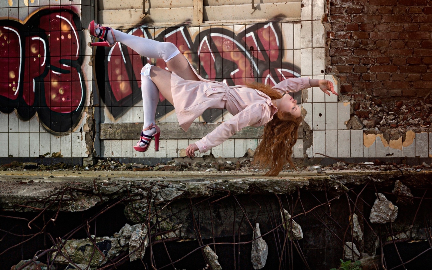 Девушка выполняет трюк на фоне граффити