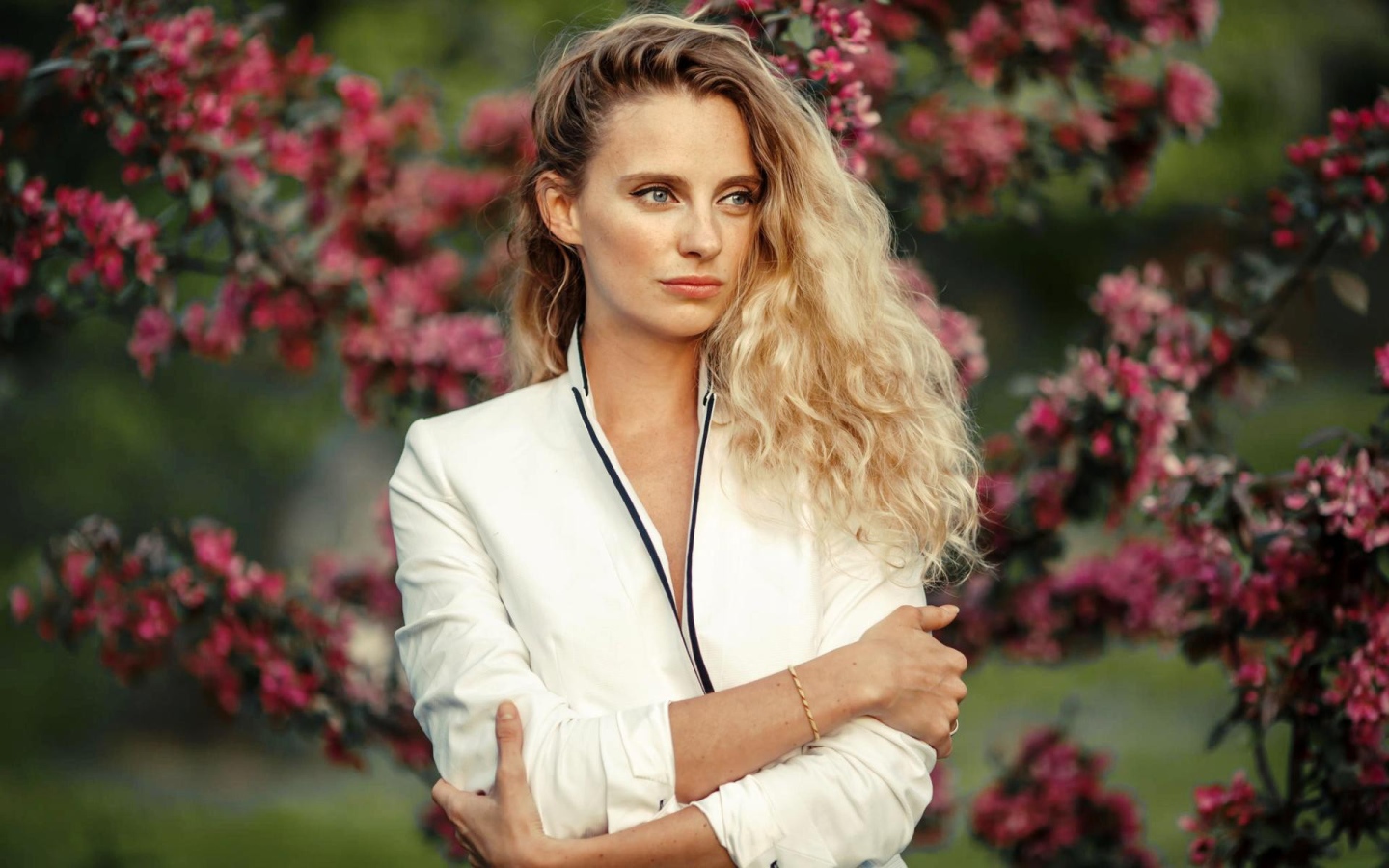 Голубоглазая блондинка на фоне цветущих деревьев