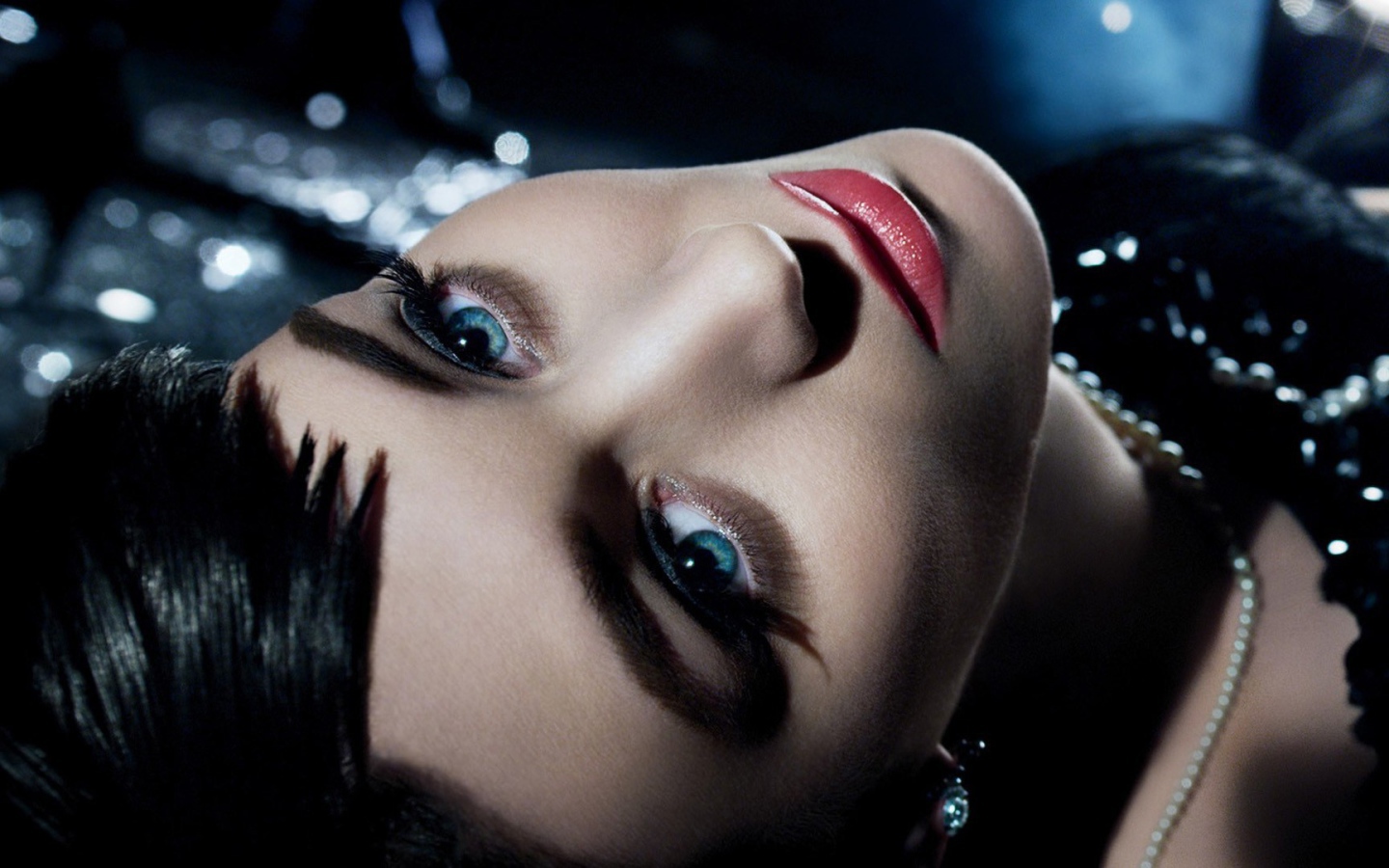 Голубоглазая брюнетка лежит в черном платье