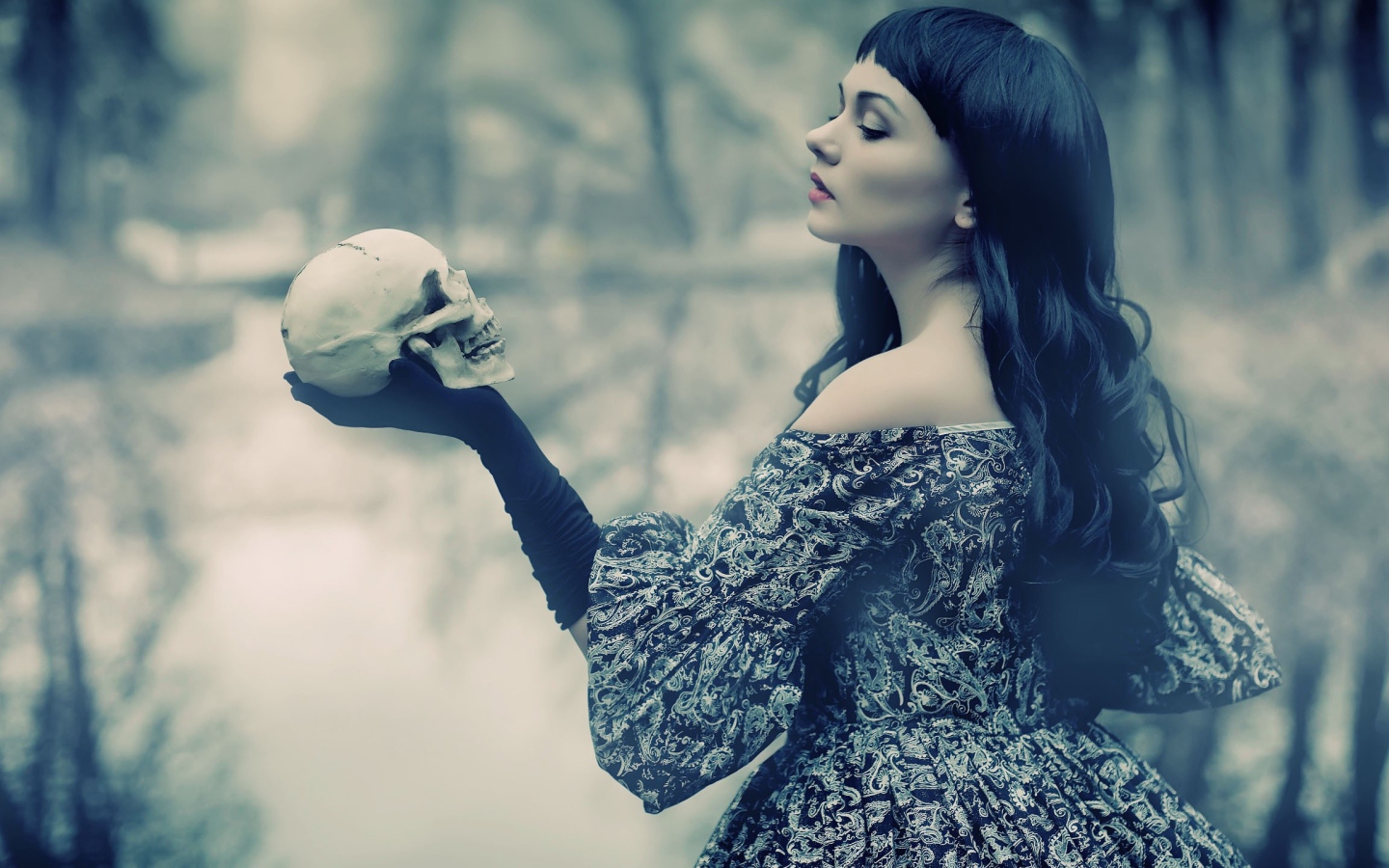 Брюнетка держит в руке череп