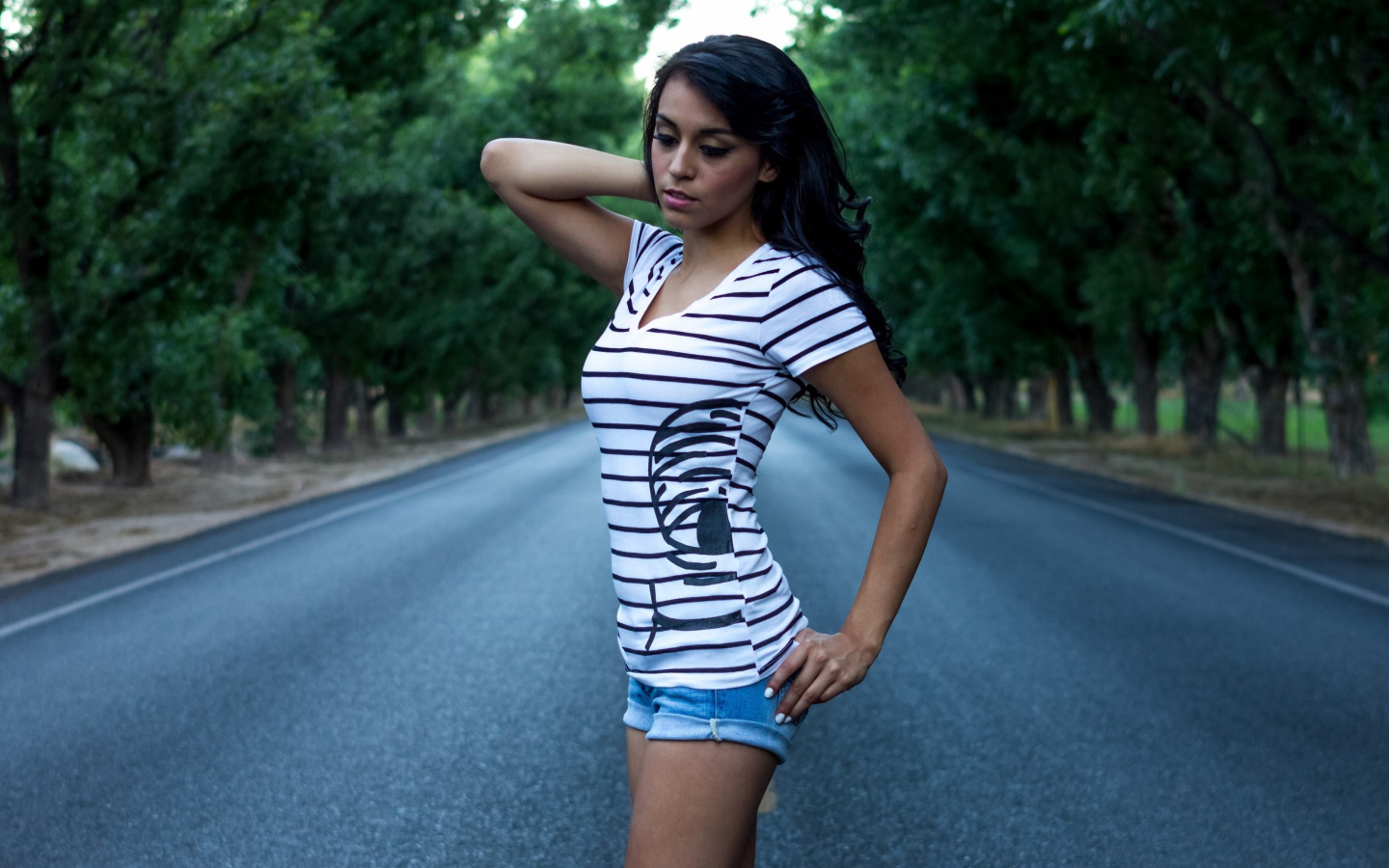 Брюнетка в джинсовых шортах среди дороги