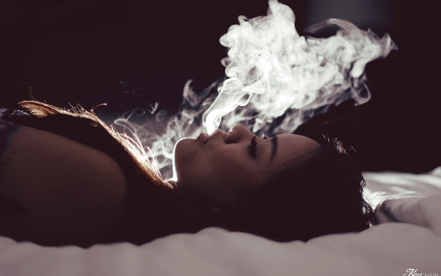 Девушка выпускает дым изо рта