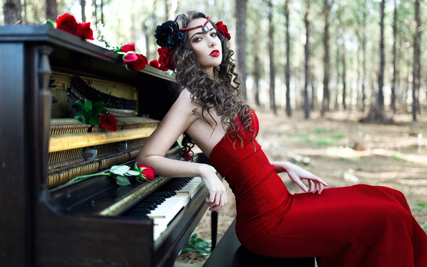 Girl in a red dress sitting at the piano
