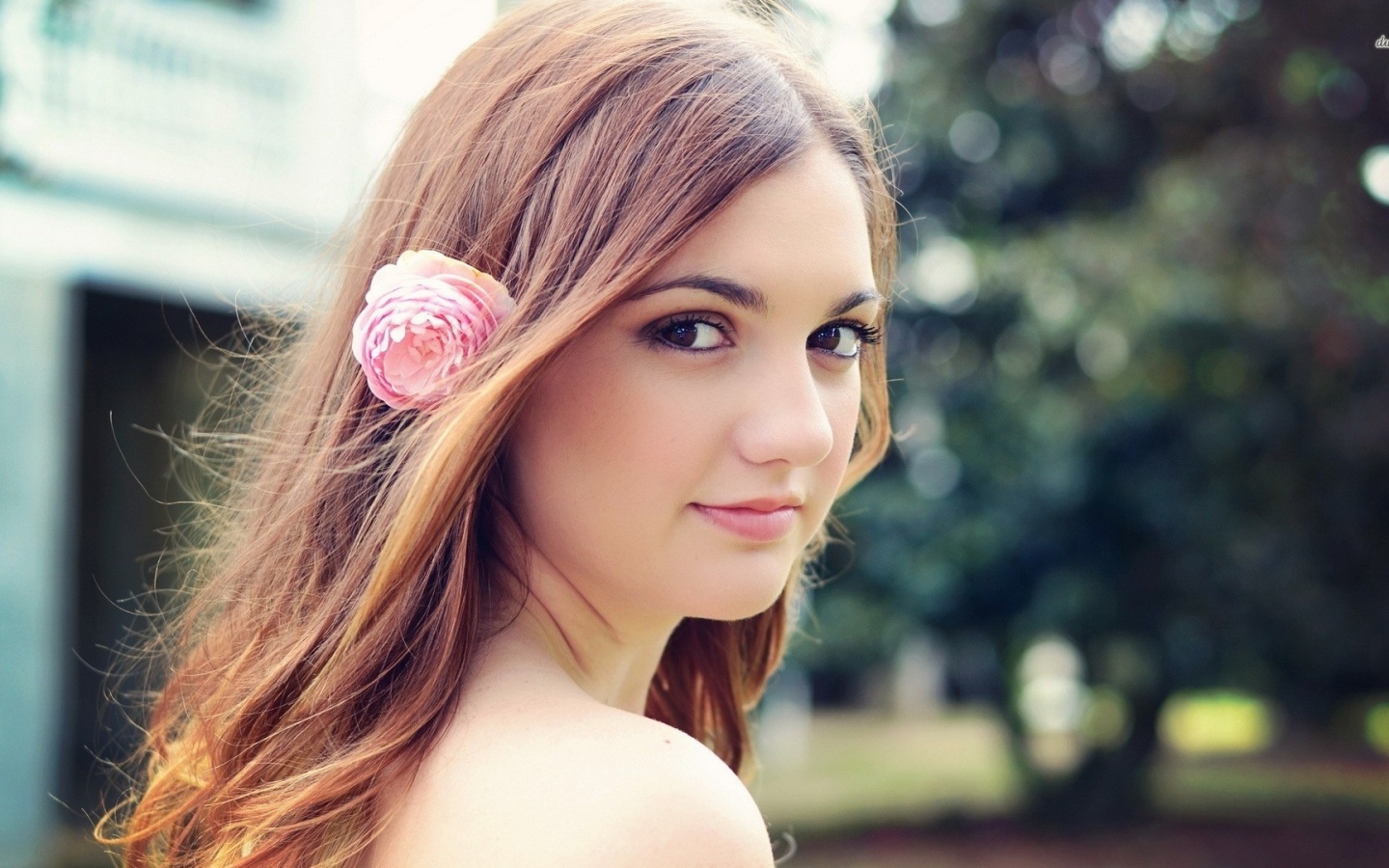 Девушка модель с розовым цветком в волосах