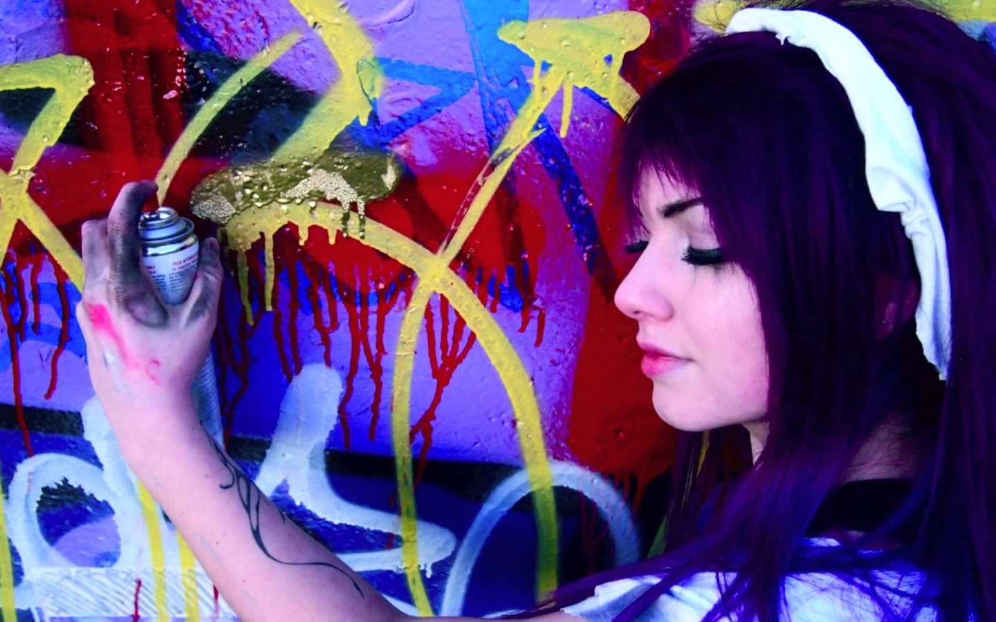 Девушка рисует граффити на стене