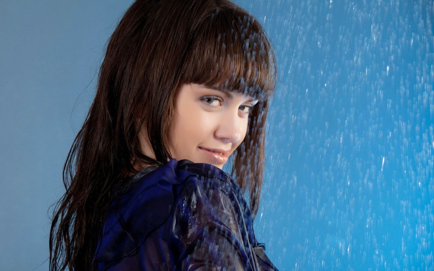 Девушка стоит под струей воды