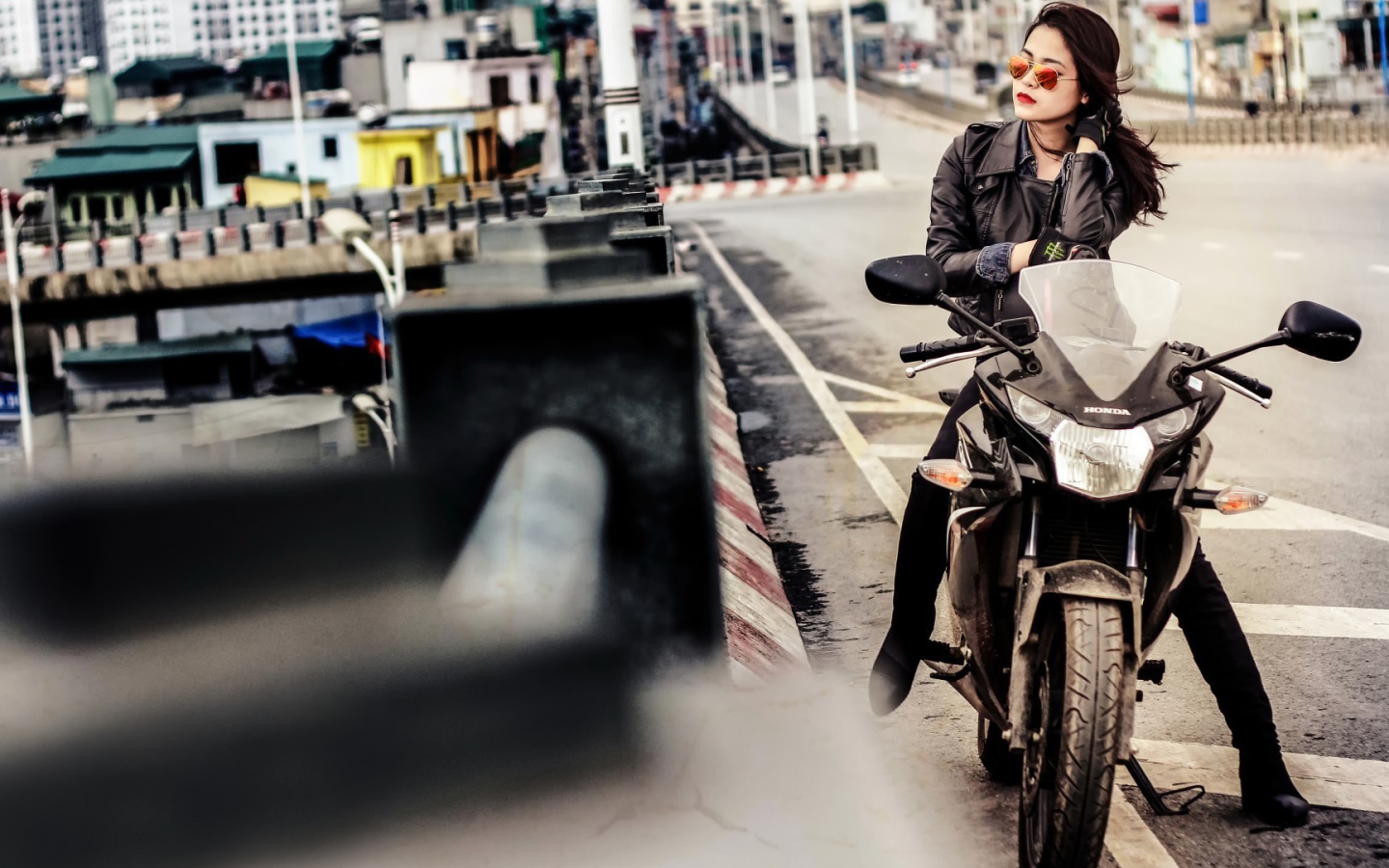 Девушка в темных очках сидит на мотоцикле