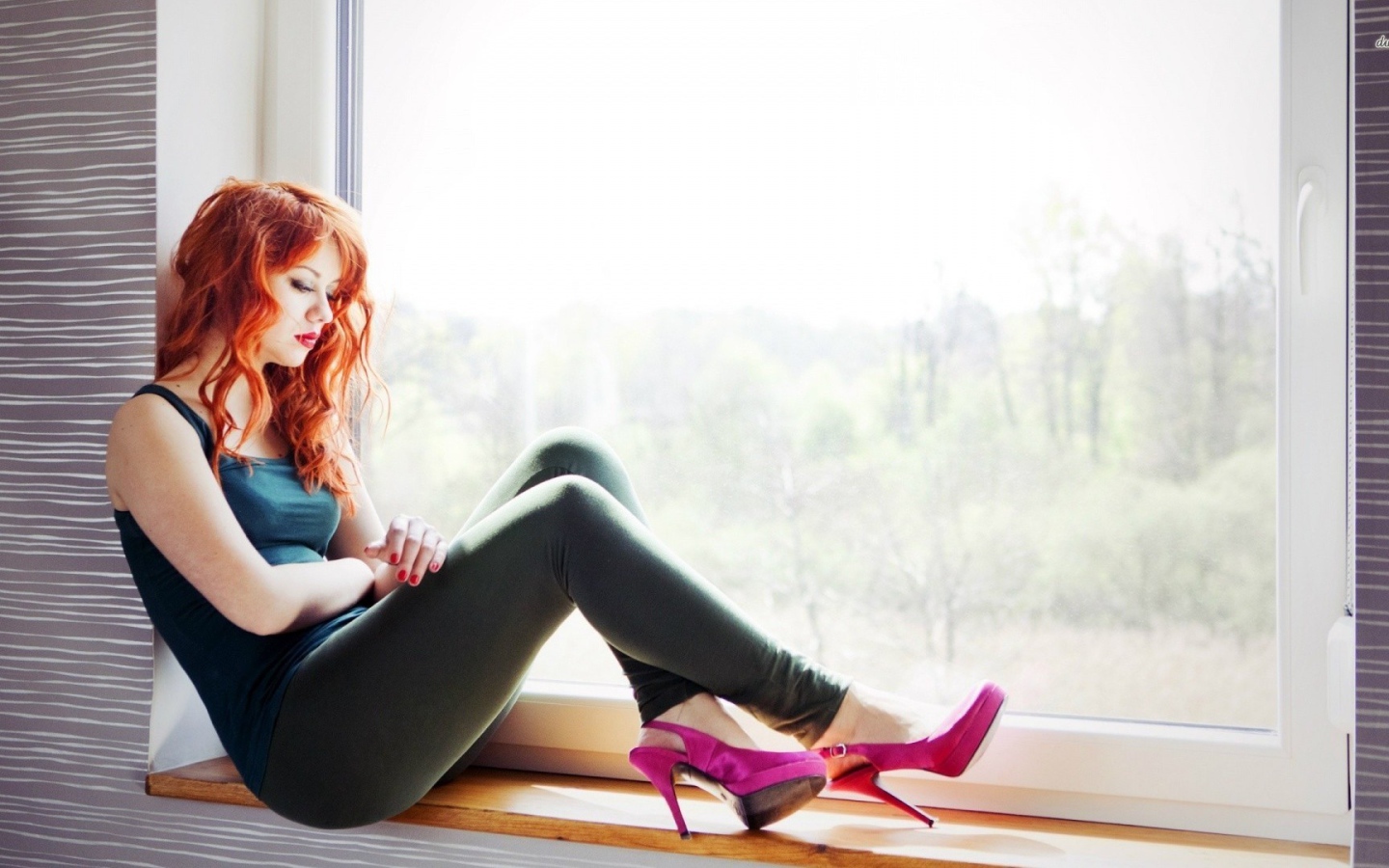 Рыжая девушка в розовых туфлях сидит на окне