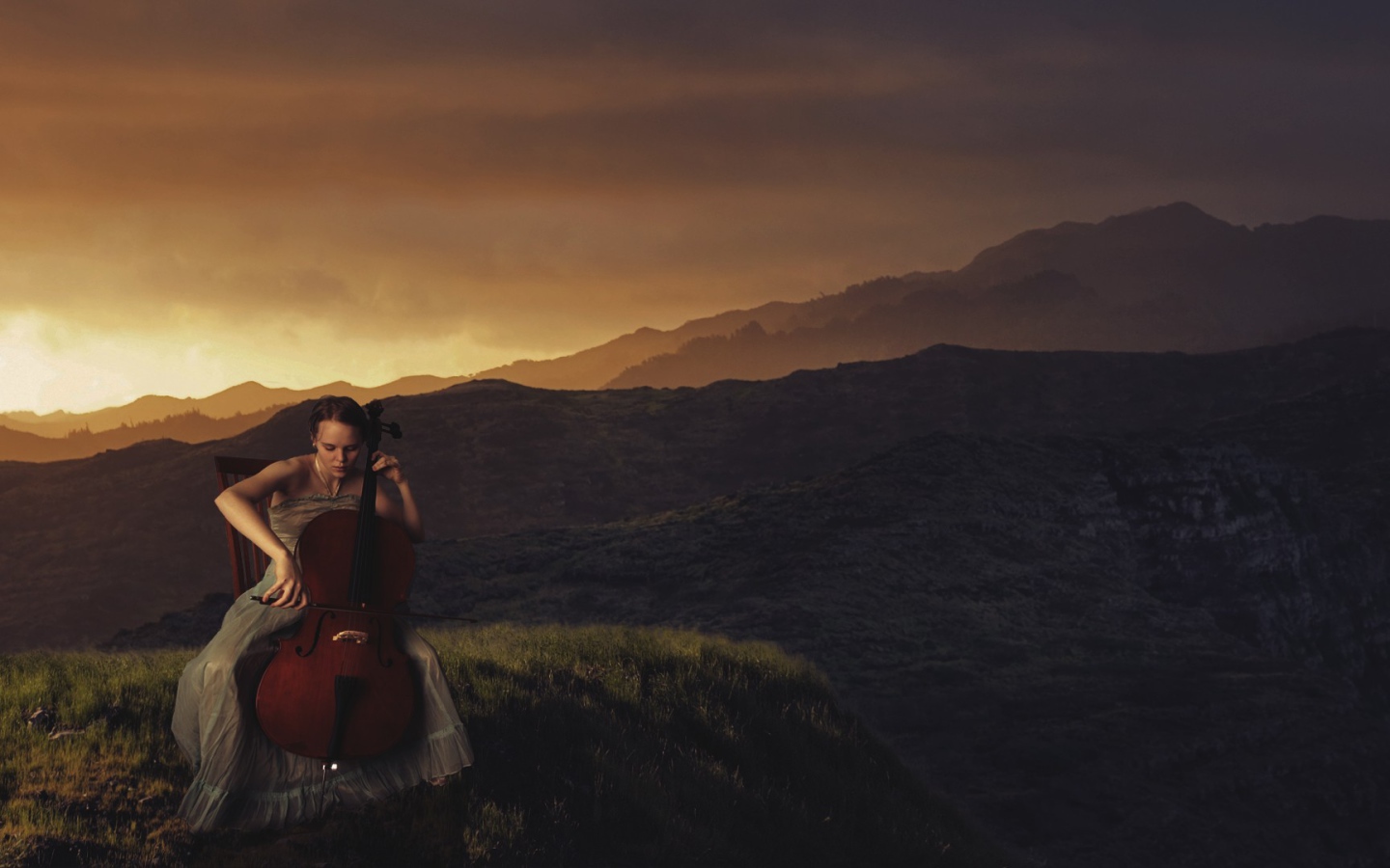Девушка играет на виолончели на фоне гор