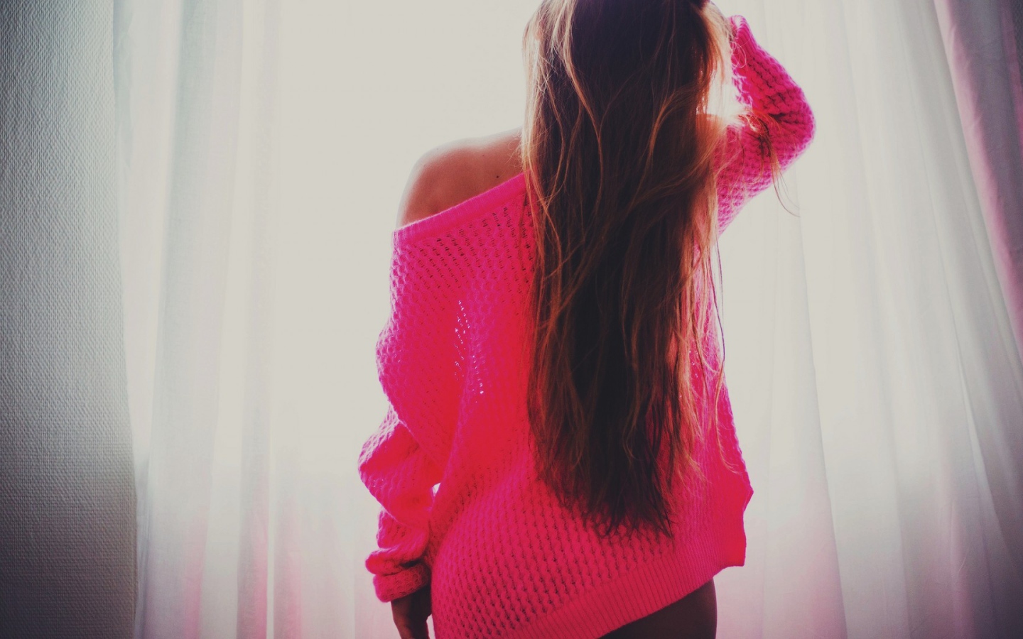 Девушка в розовой кофте стоит спиной