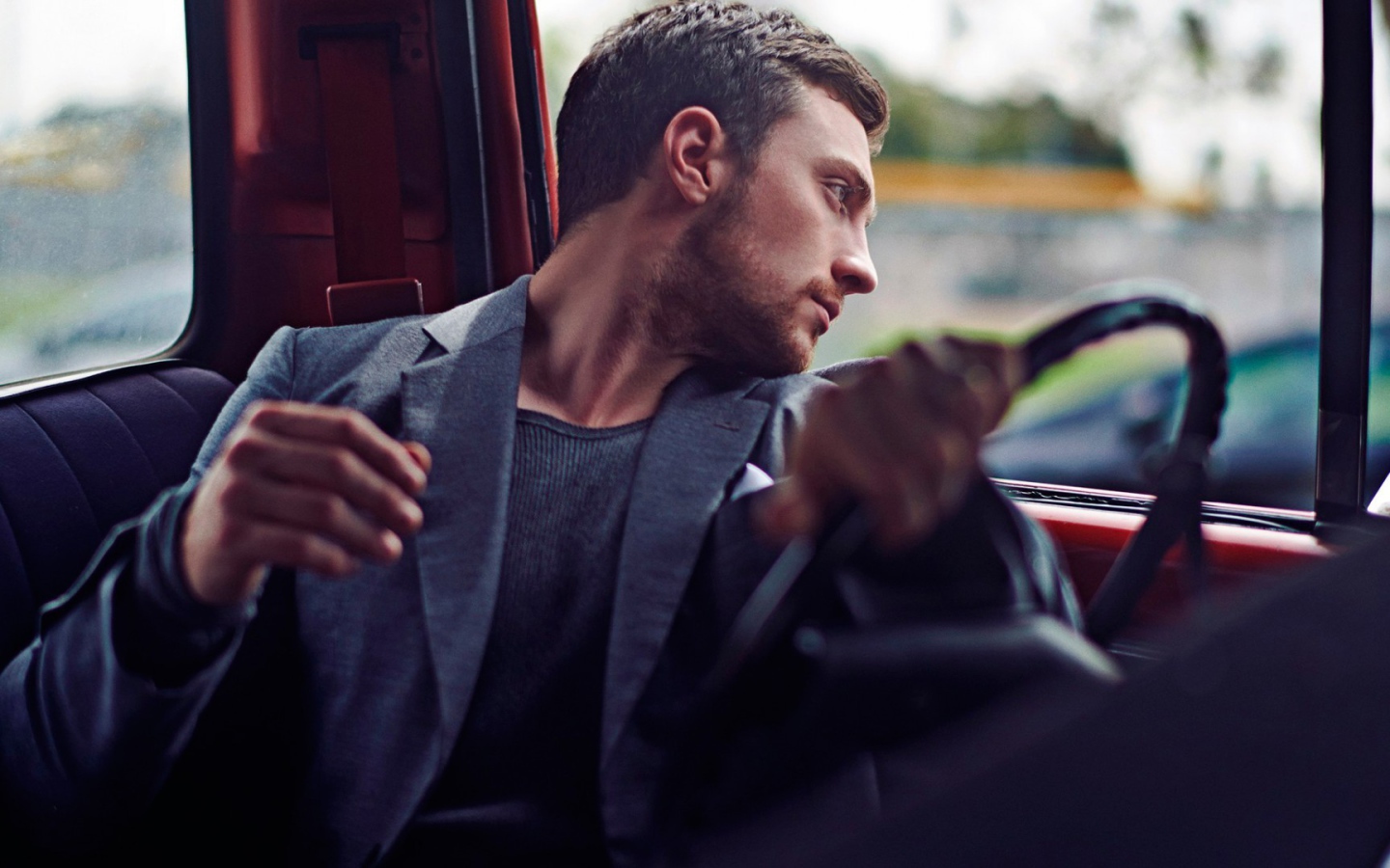 Мужчина за рулем смотрит в окно автомобиля