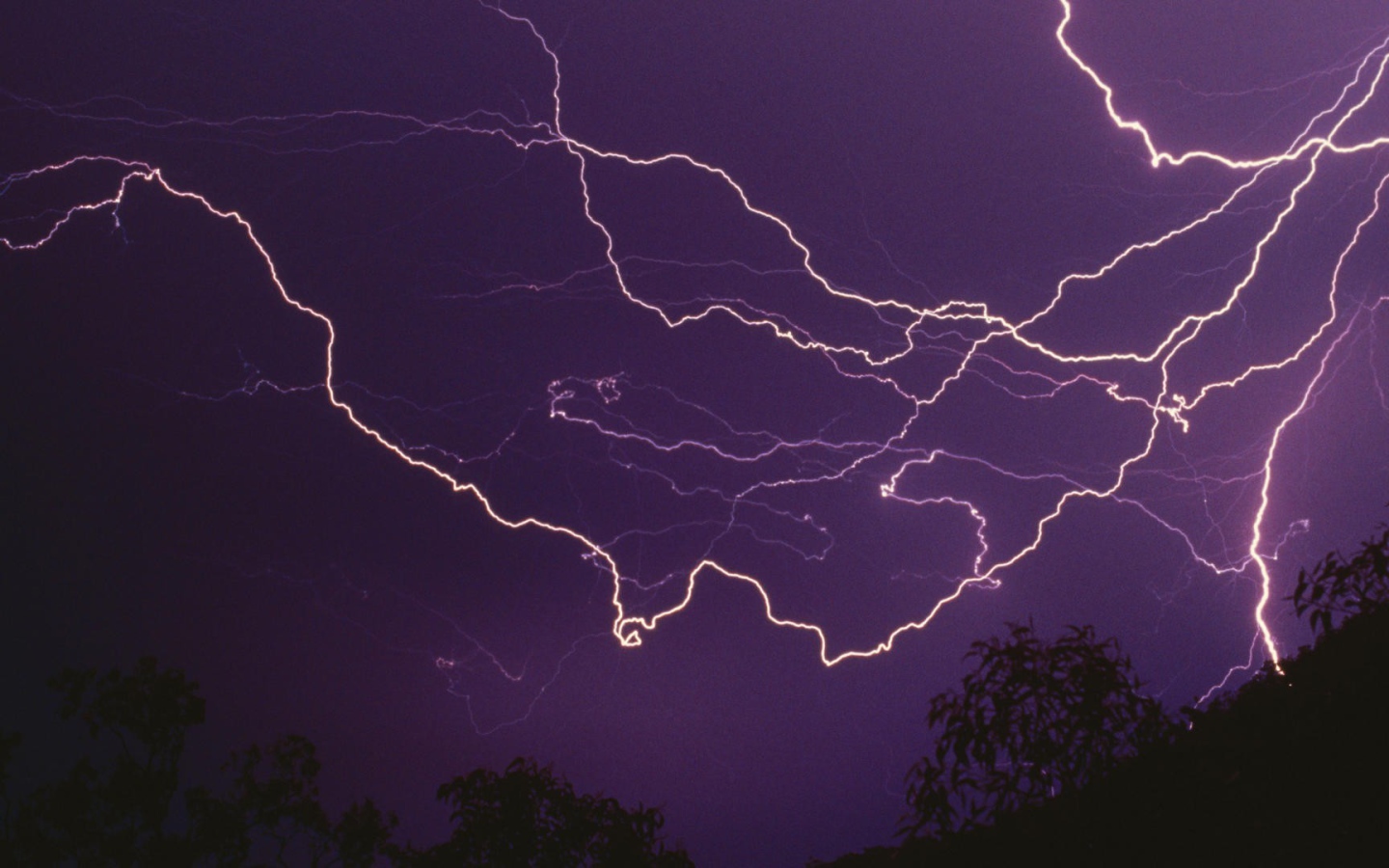 Молнии в фиолетовом небе ночью