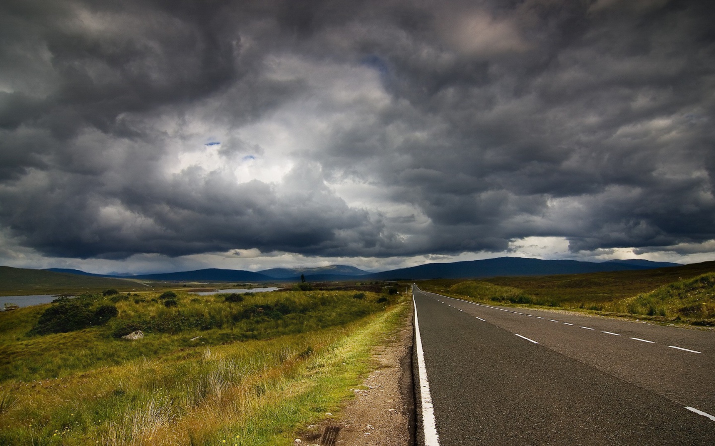 Шоссе среди полей под мрачными облаками