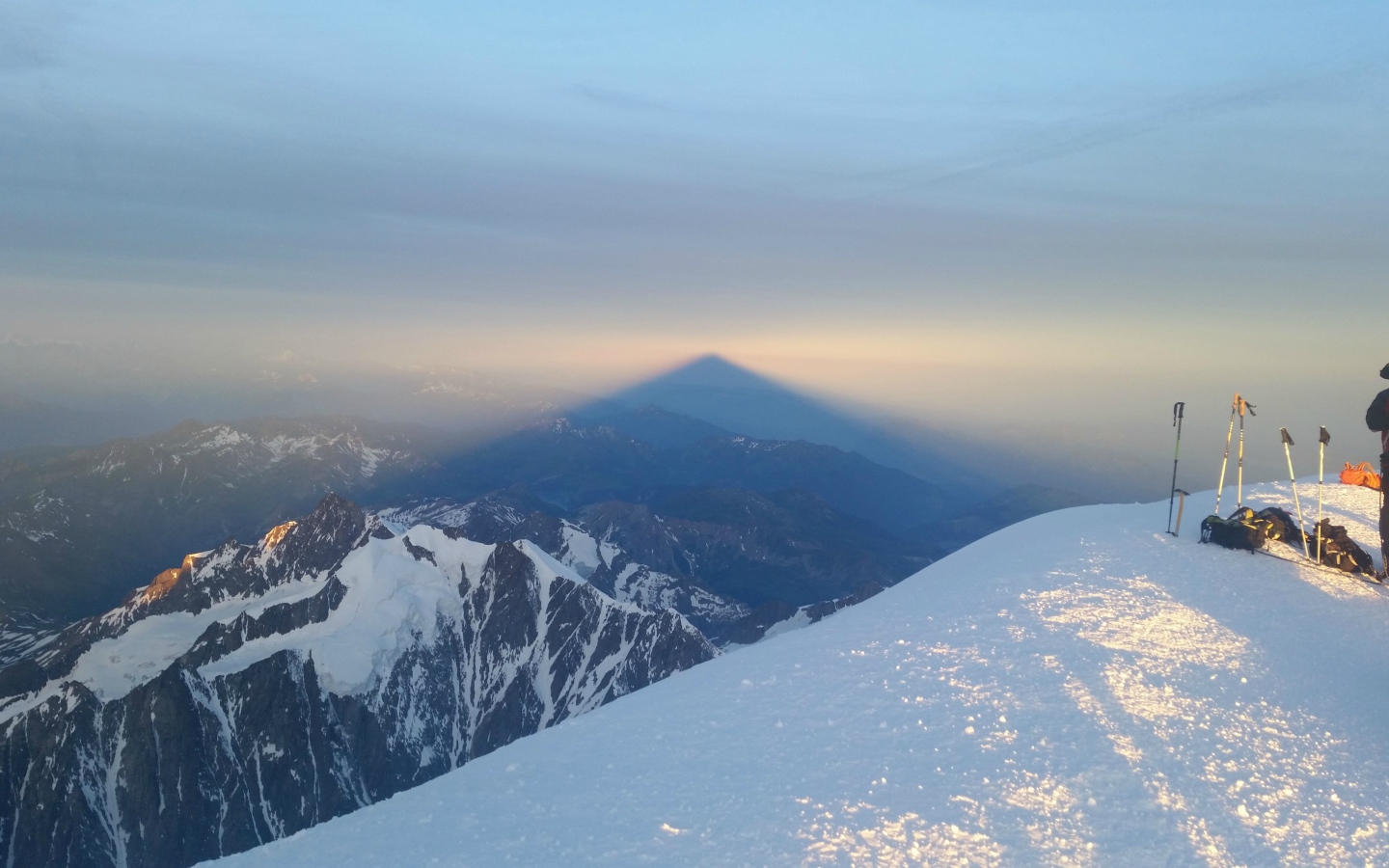 Лыжники на вершине горы перед закатом солнца