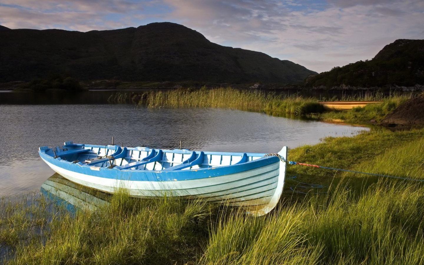 Синяя лодка на берегу озера