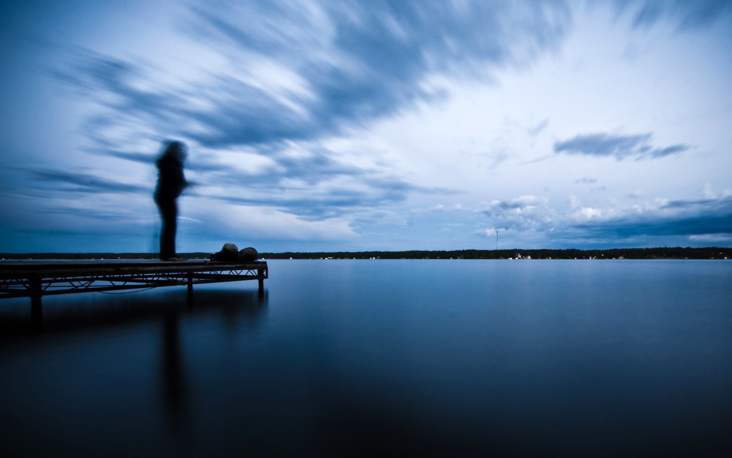 Силуэт человека на пристани у озера