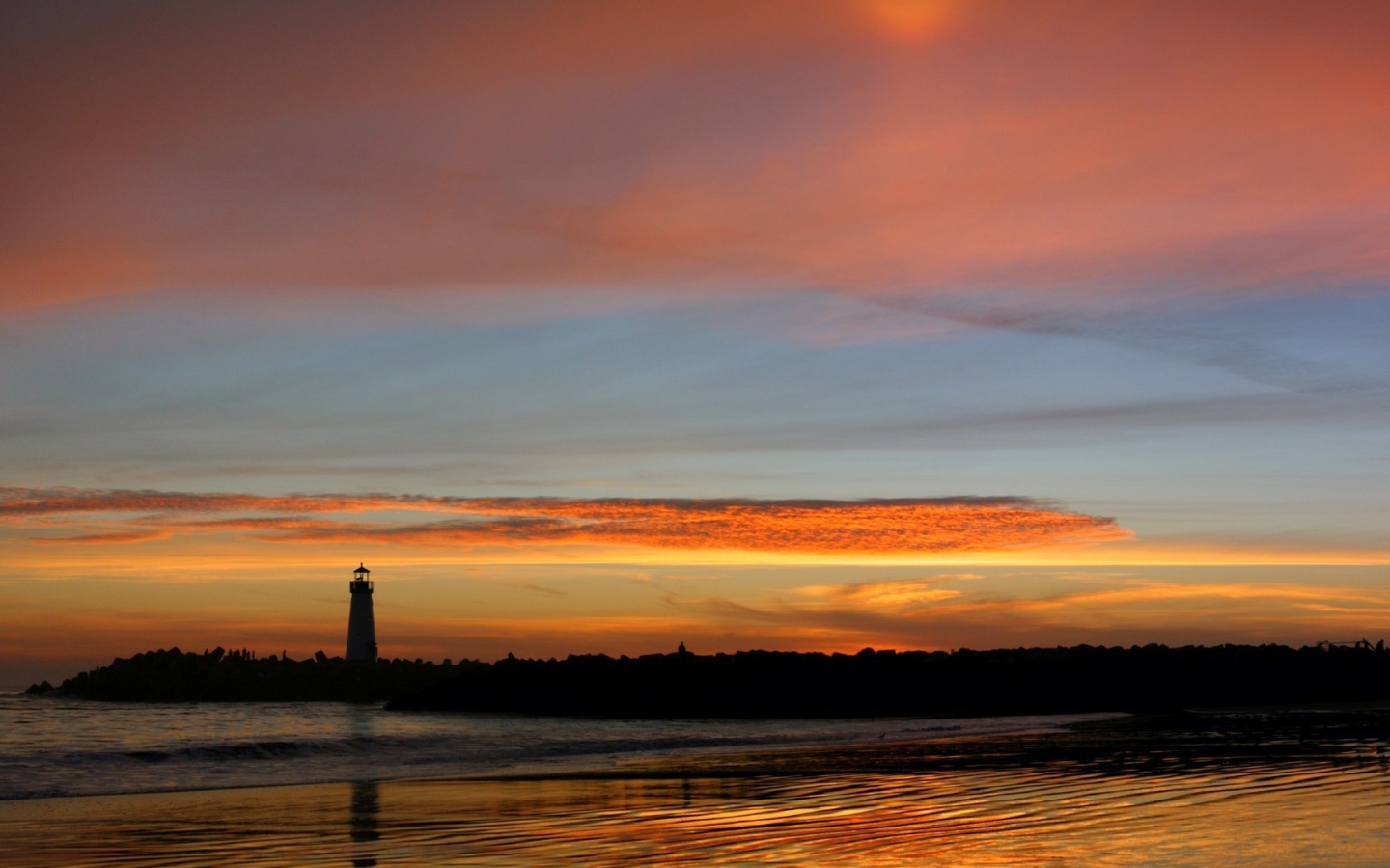 Силуэт маяка на фоне оранжевых облаков