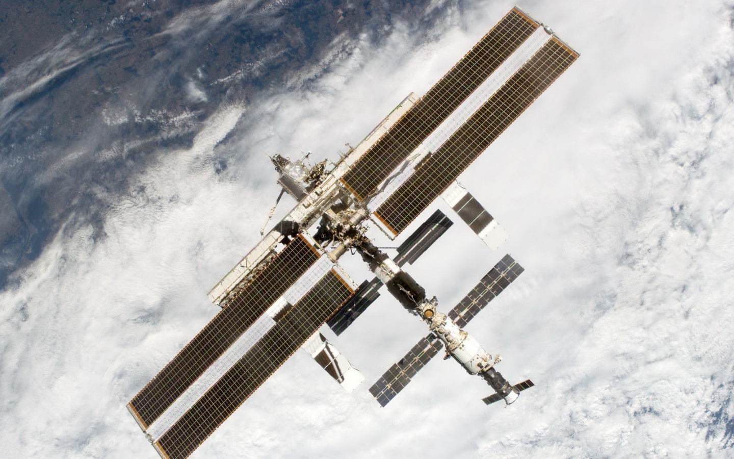 МКС пролетает над облаками на Земле