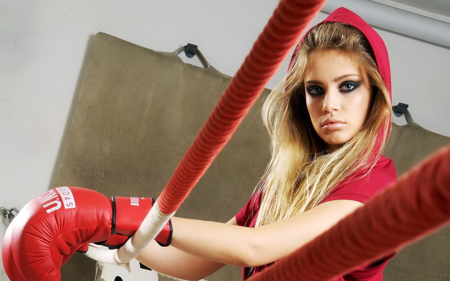 Блондинка в перчатках на боксерском ринге